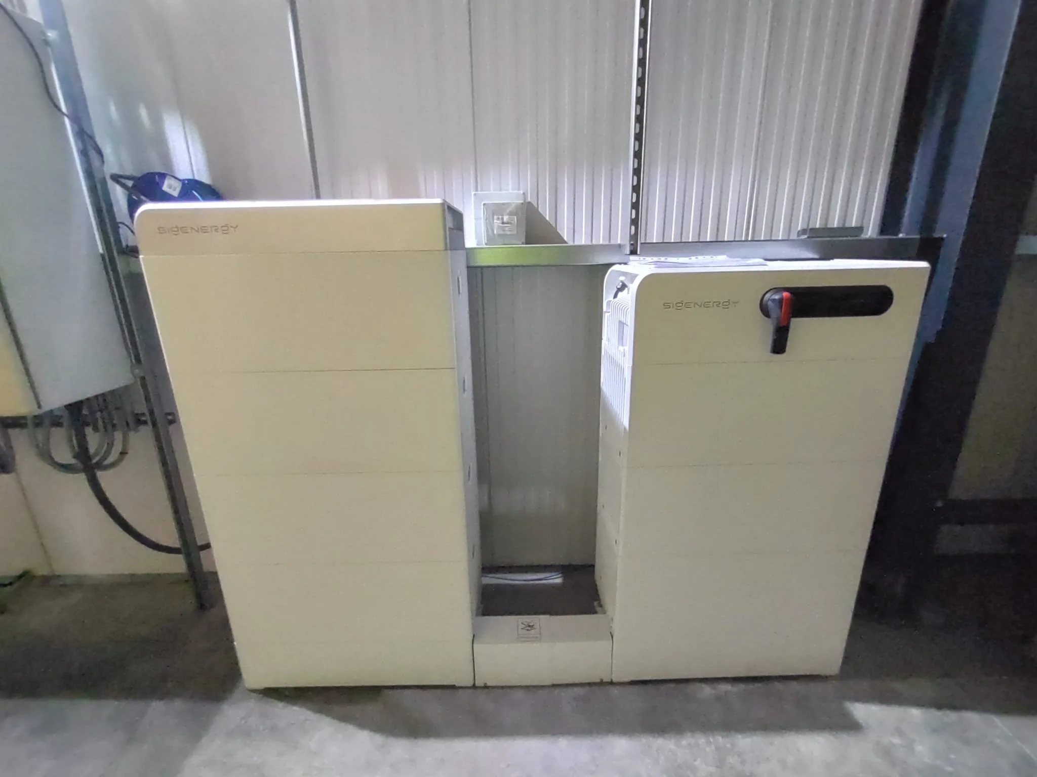 Large white and gray industrial machine labeled 'SIGENERGY' in a warehouse setting.