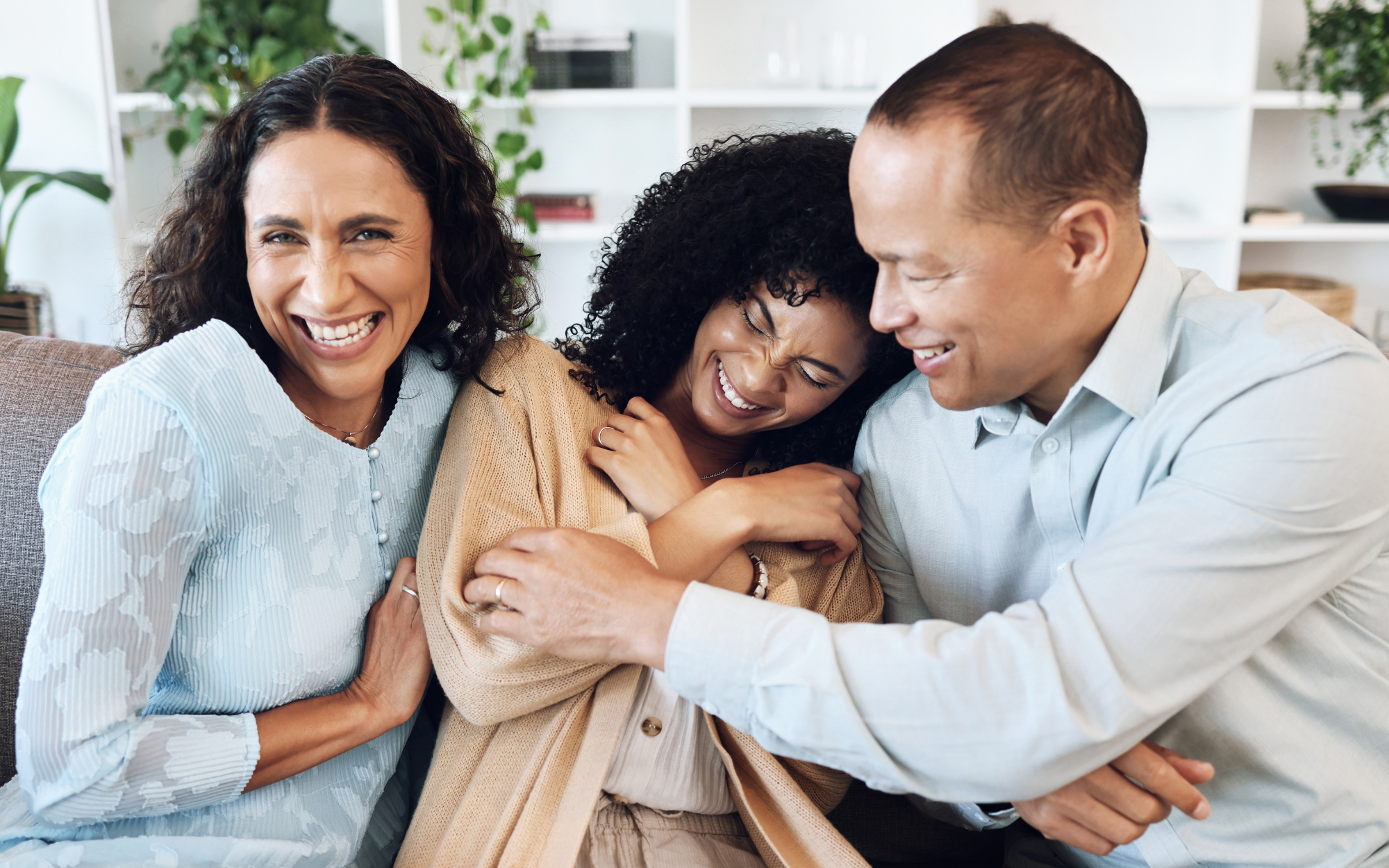 Family hugging and smiling in living room