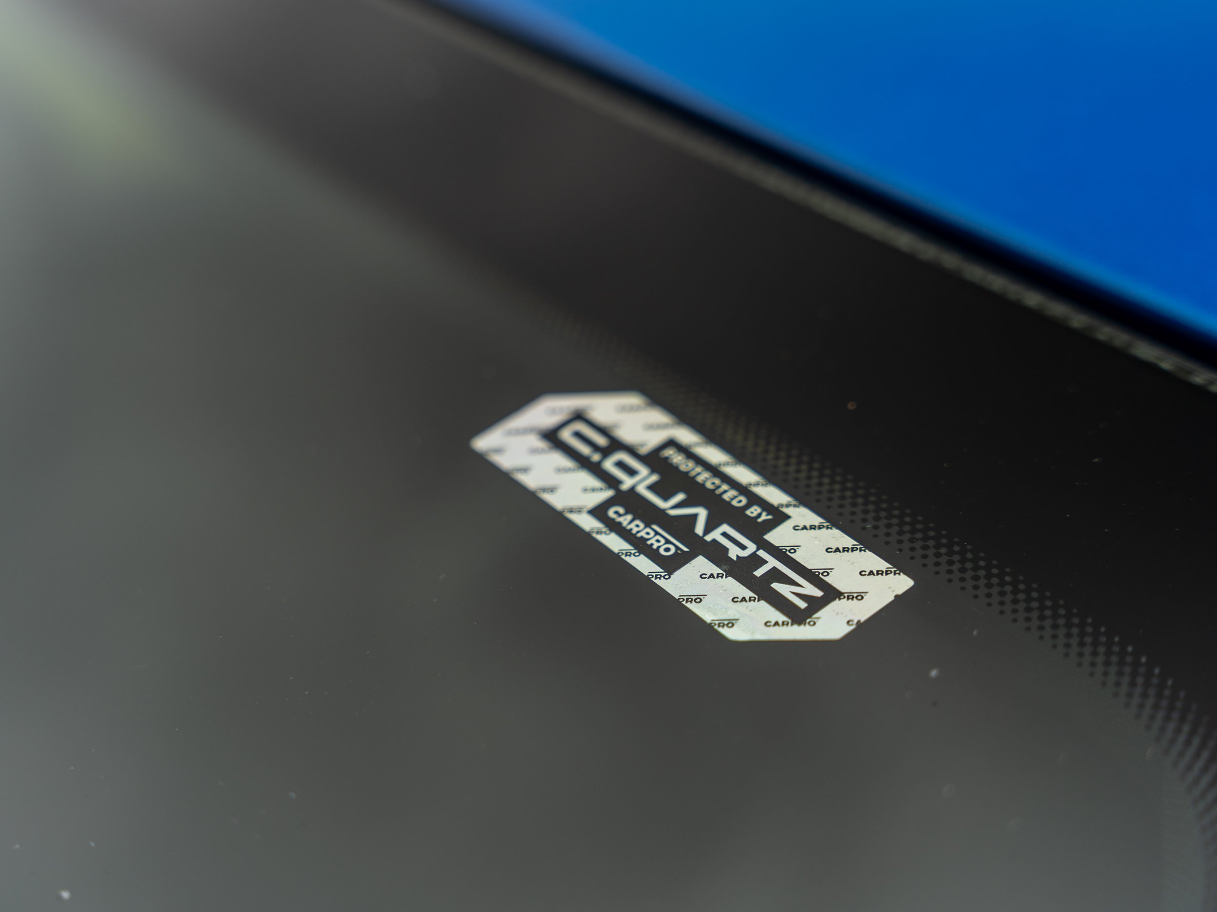 Close-up of a sticker on a car dashboard reading 'Protected by EAGLEGUARD CarPro'.