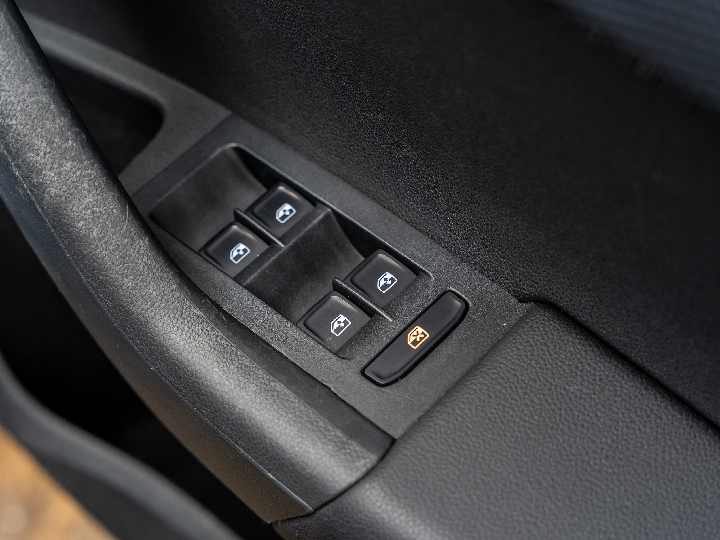 Car window control panel with four power window switches and one window lock button.