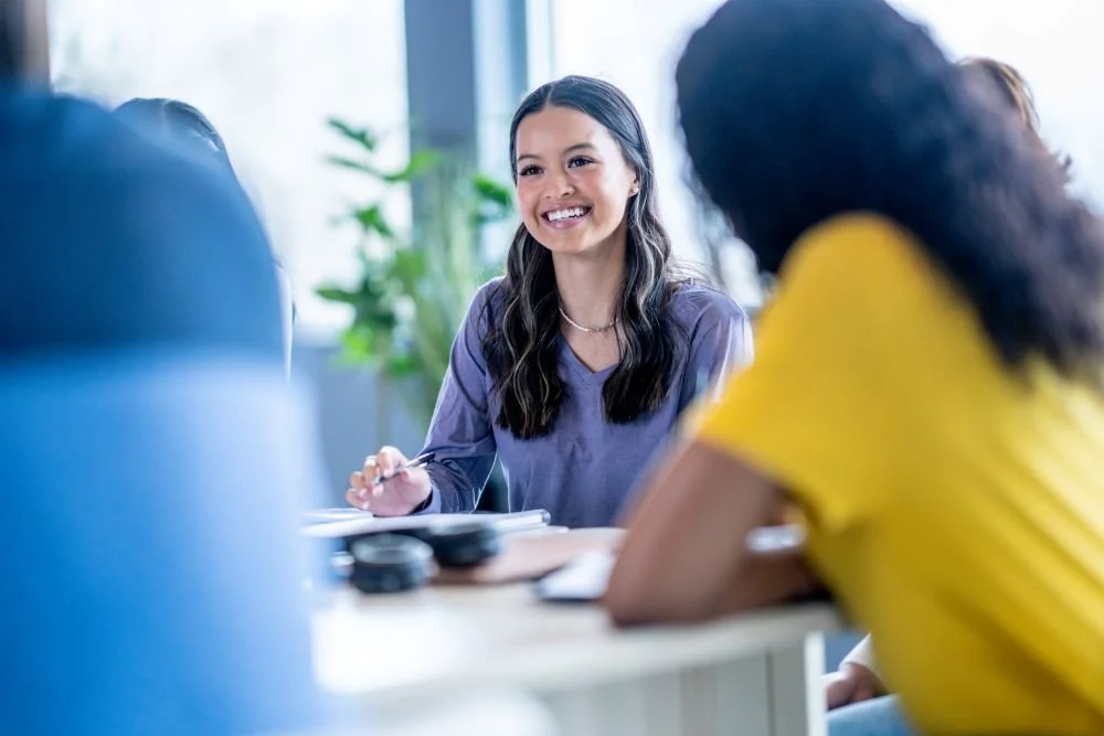 Young woman confidently leading a group of peers.