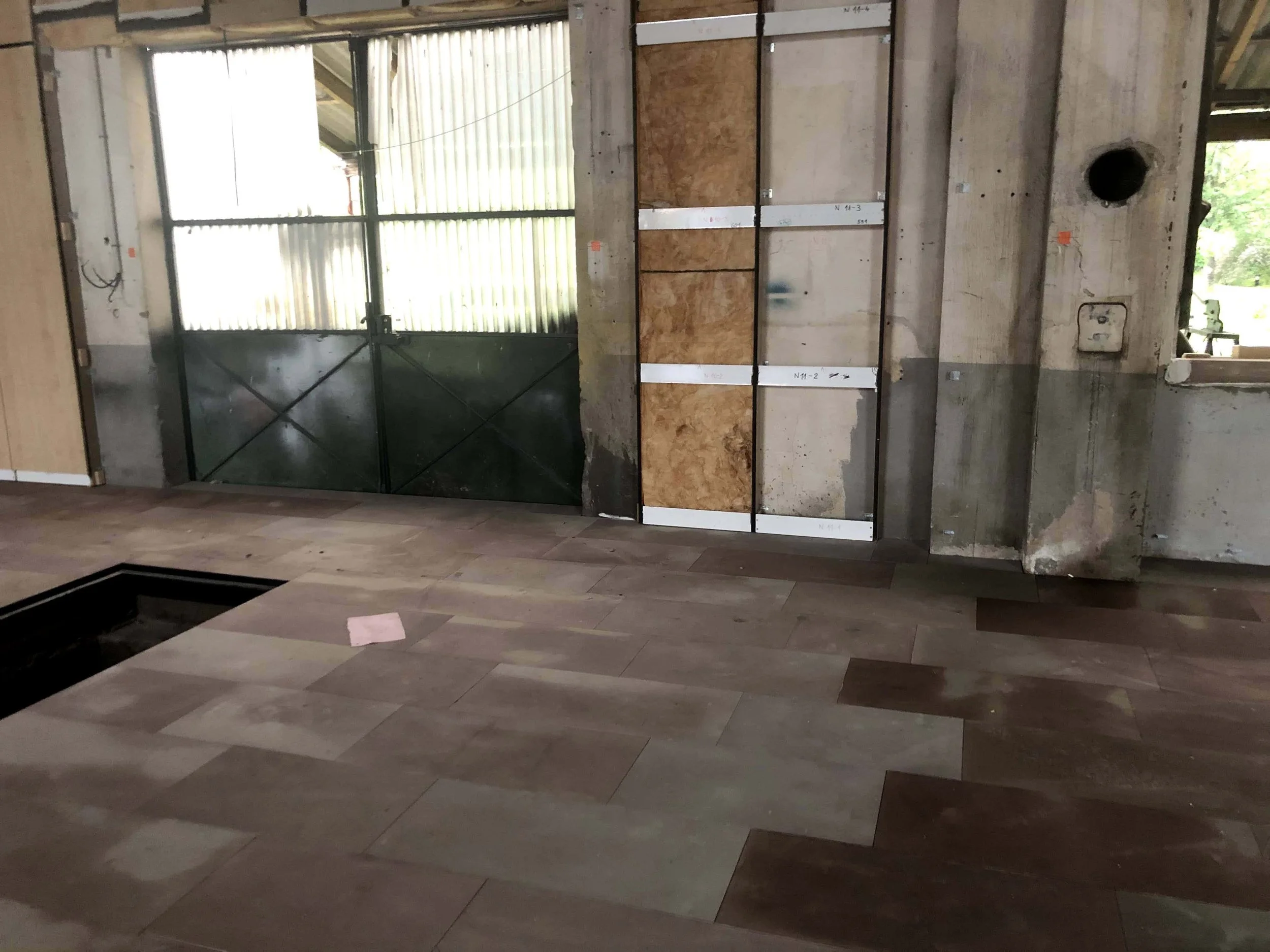 Intérieur en chantier avec le nouveau sol en grès des Vosges apparent et la nouvelle isolation thermique et phonique en cours d'installation.