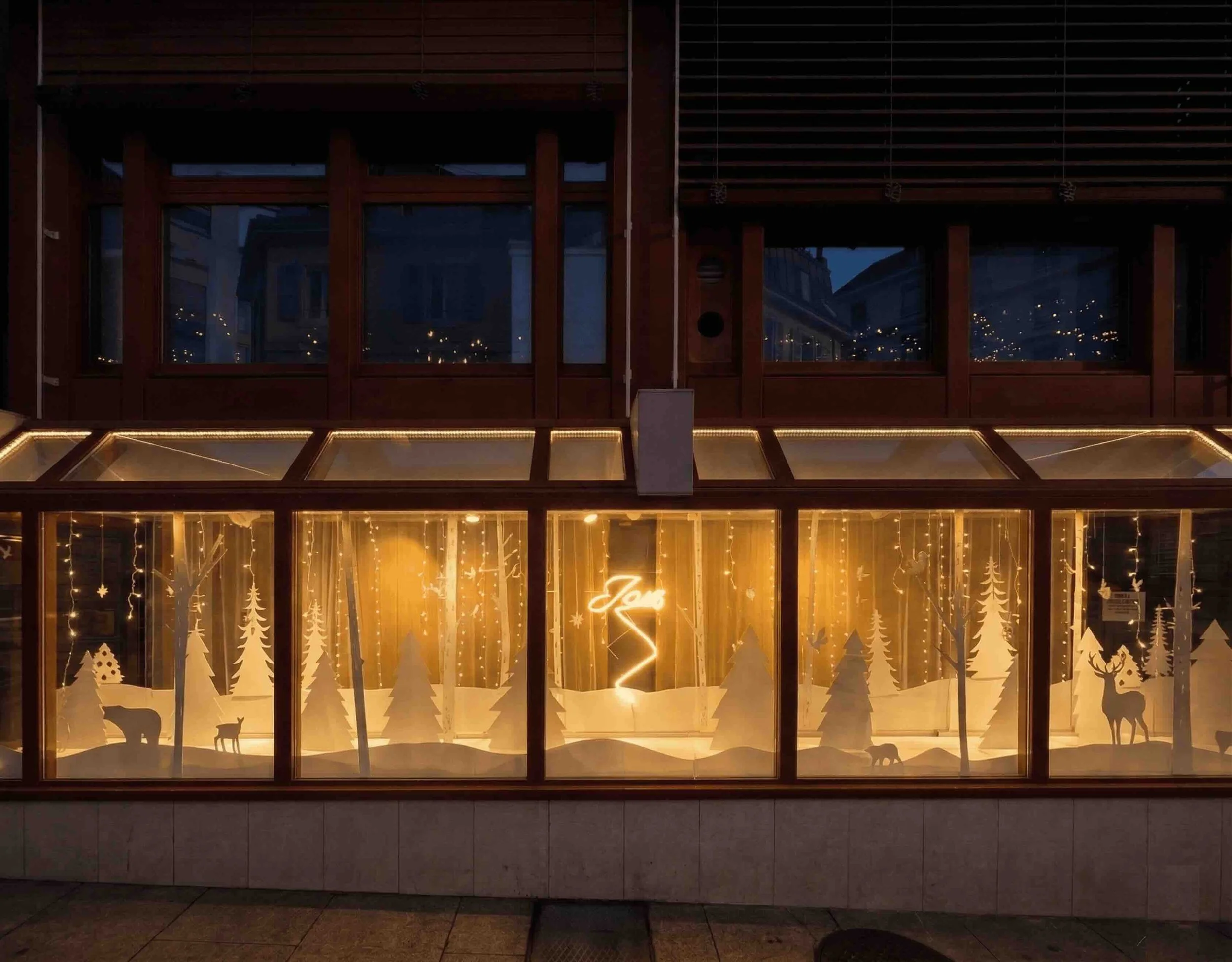 Aménagement de vitrine à Genève : scénographie hivernale lumineuse en diorama. Ses strates superposées créent une micro-architecture immersive.