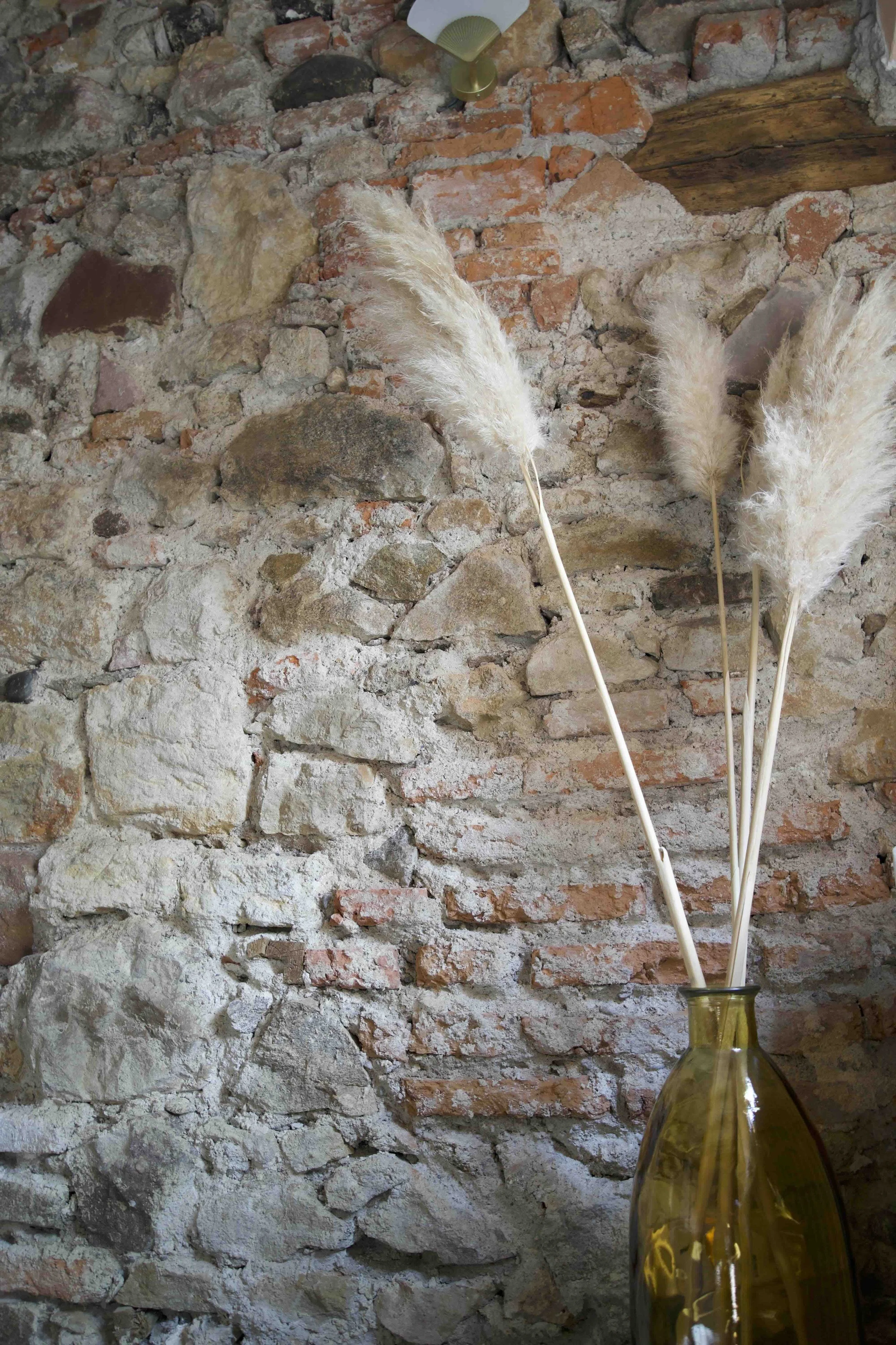 Restauration du patrimoine par un architecte à Genève : gros plan sur un mur authentique en bois, pierre et brique entièrement décapé pour révéler l'appareillage d'origine.