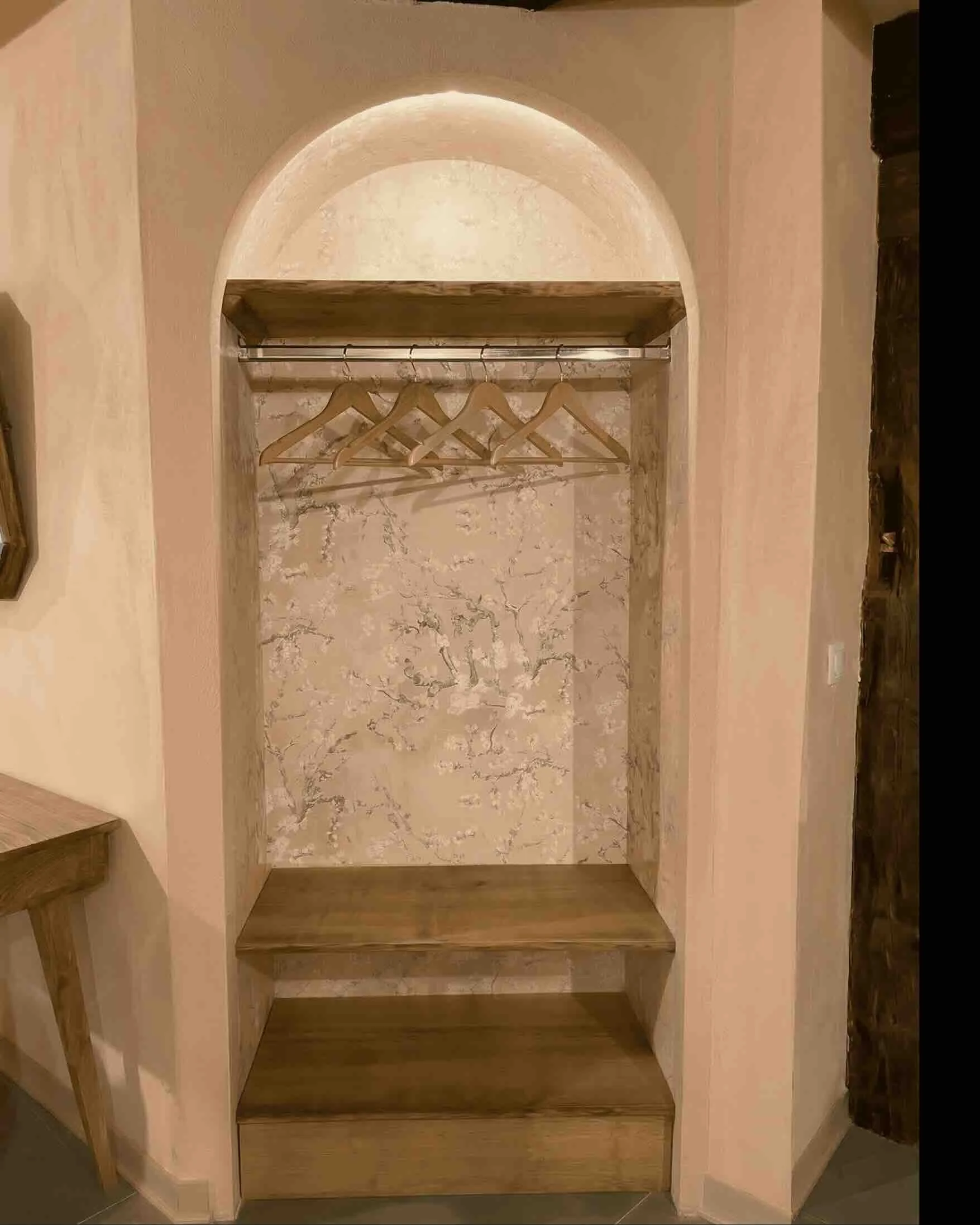 Aménagement sur-mesure à Genève : ancienne alcôve transformée en espace penderie par un architecte, décorée d'une tapisserie florale subtile pour inviter la nature à l'intérieur.