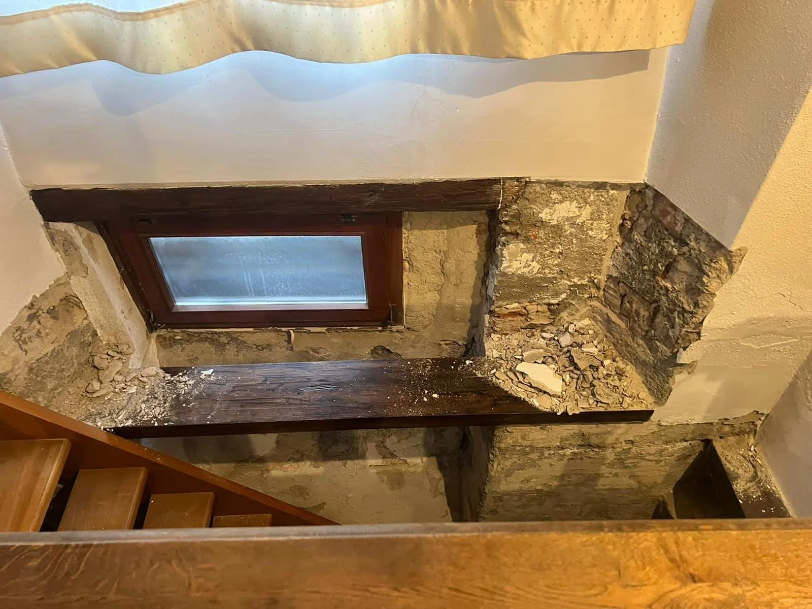 Profond encadrement de fenêtre révélant la maçonnerie en pierre d'origine, un détail authentique de l'architecture locale à Genève.