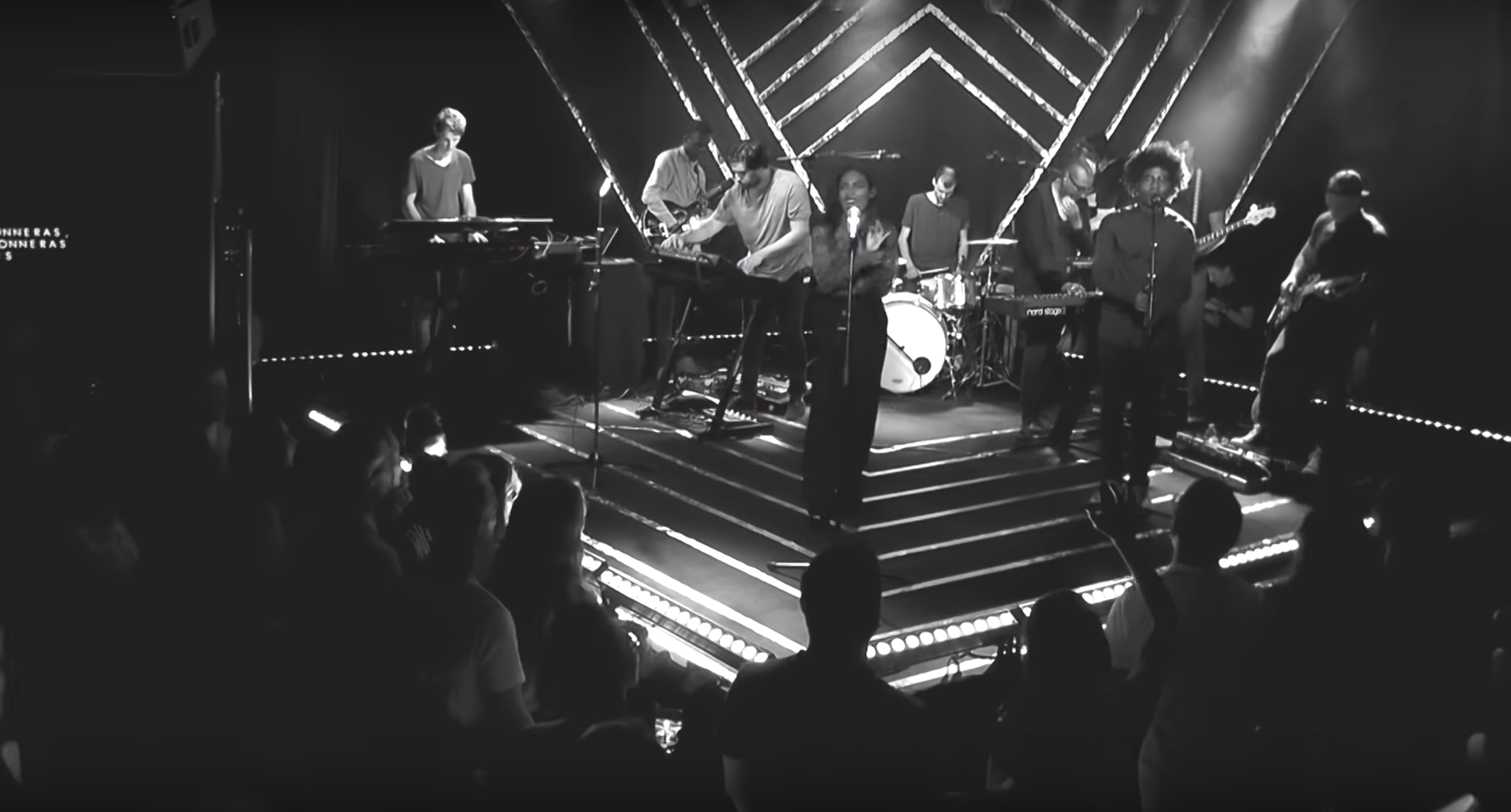 Photographie en noir et blanc d'un concert illustrant notre conception d'architecture éphémère à Genève : l'estrade classique a été repensée en une scène en forme de losange, créant une forte dynamique visuelle immersive qui projette les musiciens.