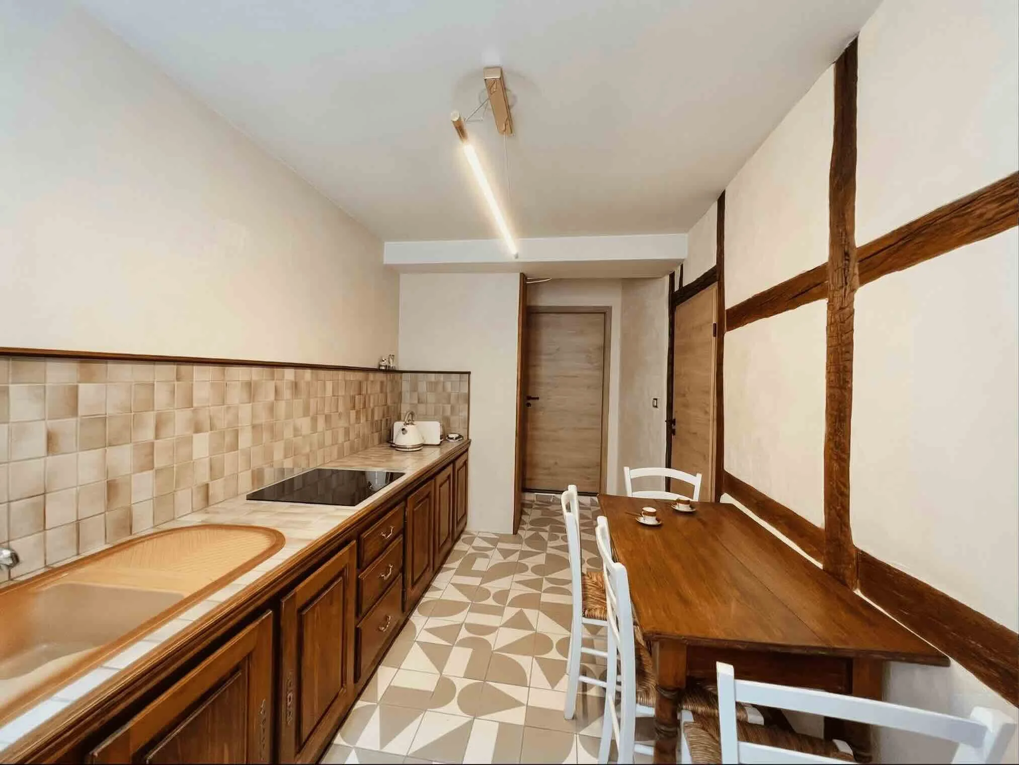 Architecte d'intérieur à Genève, cuisine de caractère, rénovation d'un mobilier traditionnel en bois avec carreaux de ciment aux motifs géométriques modernes.