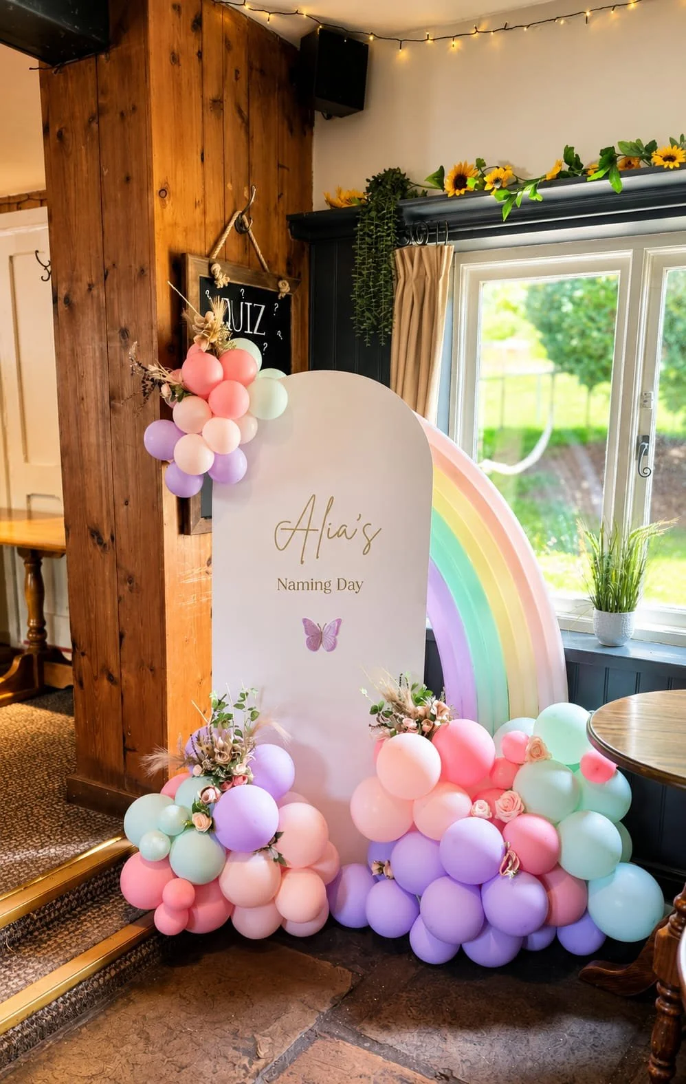 Personalised Naming Day sailboard with pastel rainbow balloons, bespoke styling and elegant event décor in Stevenage, Hertfordshire. 