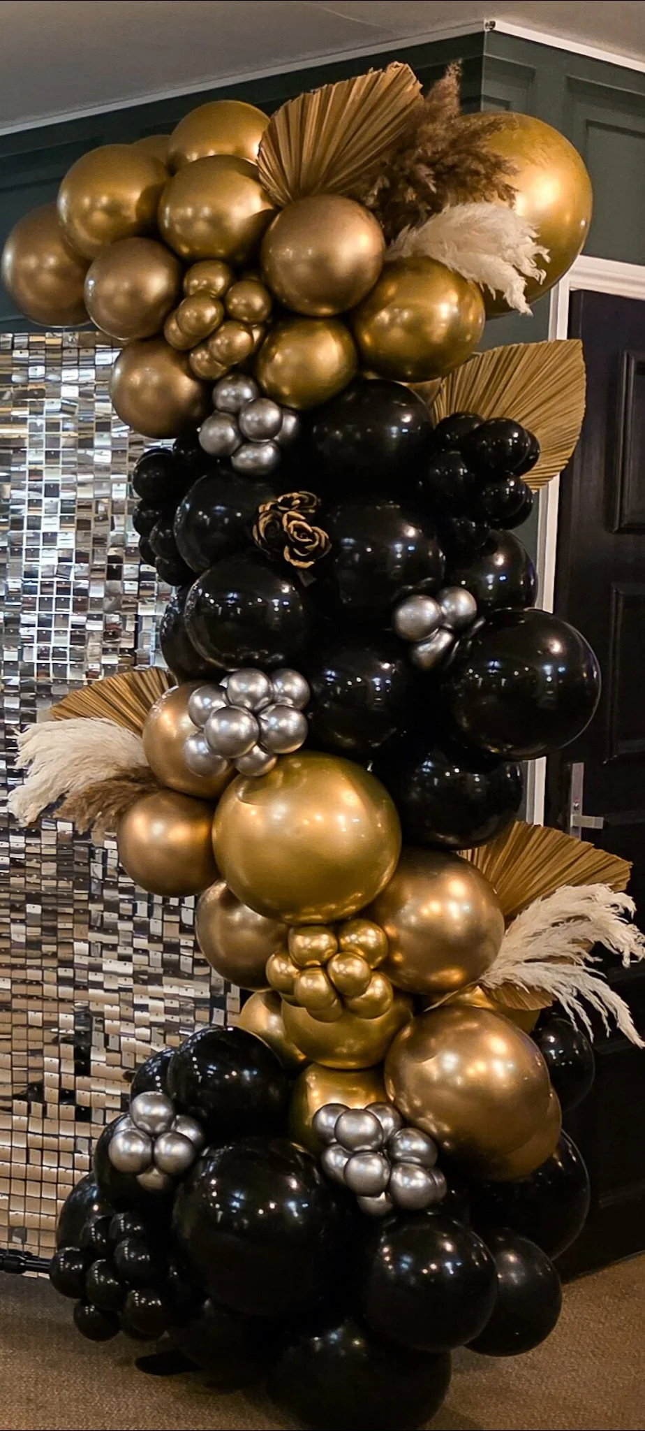 Luxury black and gold balloon display in Hertfordshire with metallic balloons and palm leaf styling, perfect for birthdays and special events