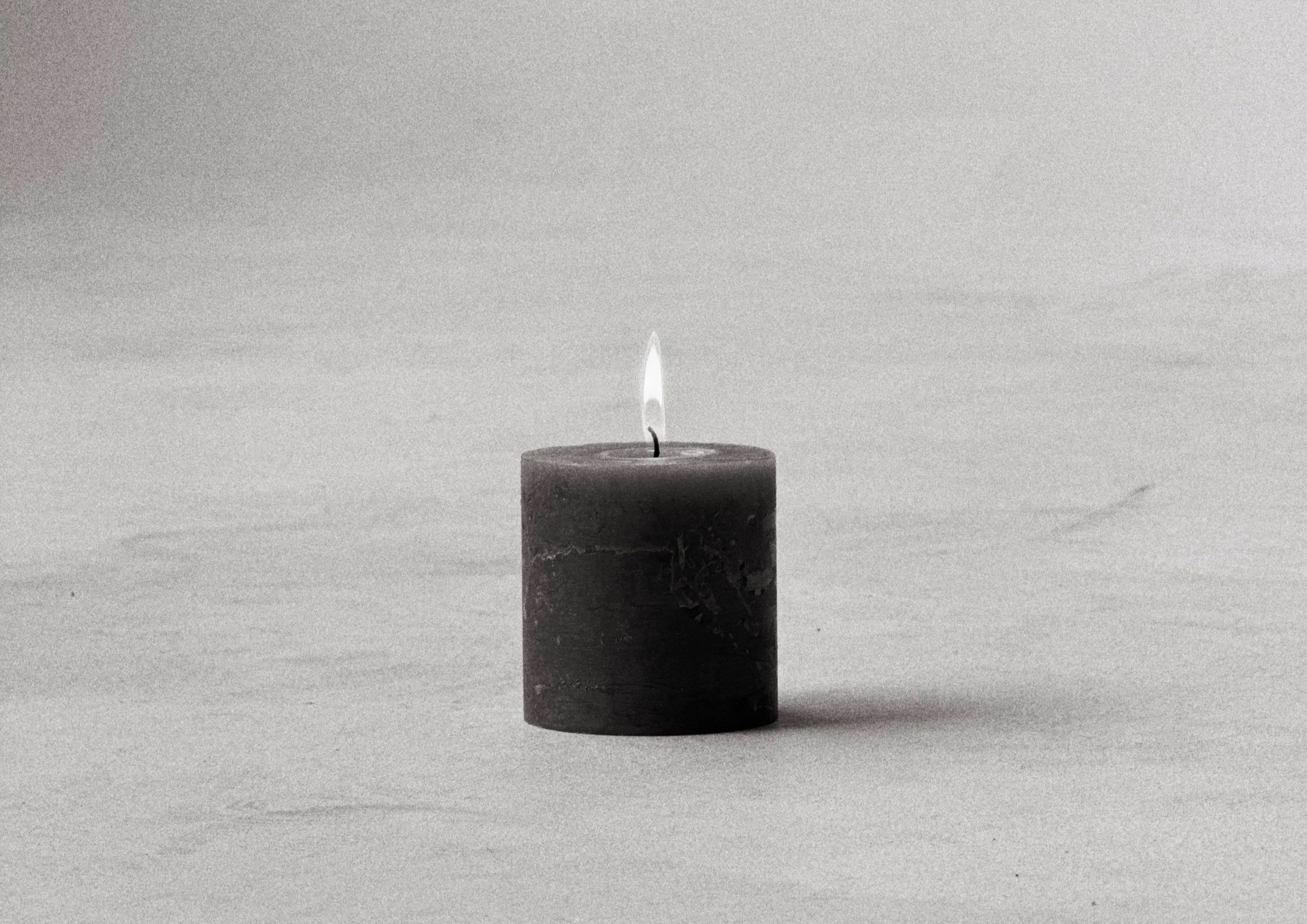 Zapálená svíčka v klidném minimalistickém prostoru