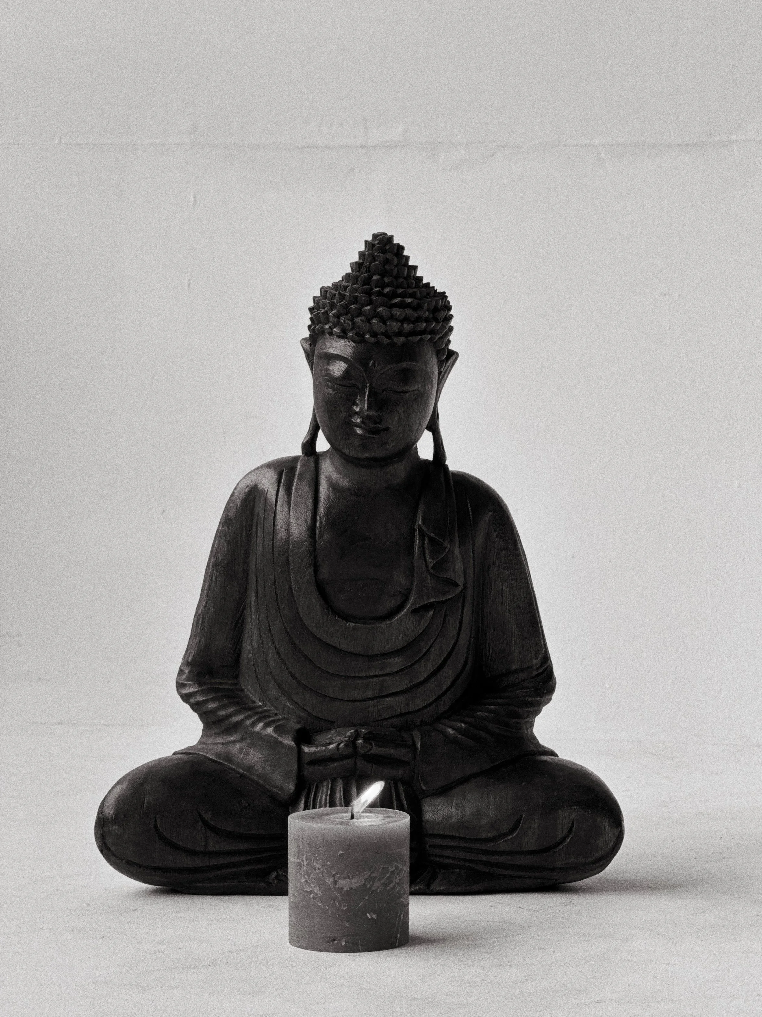 Socha Buddhy se svíčkou v klidném meditačním prostoru