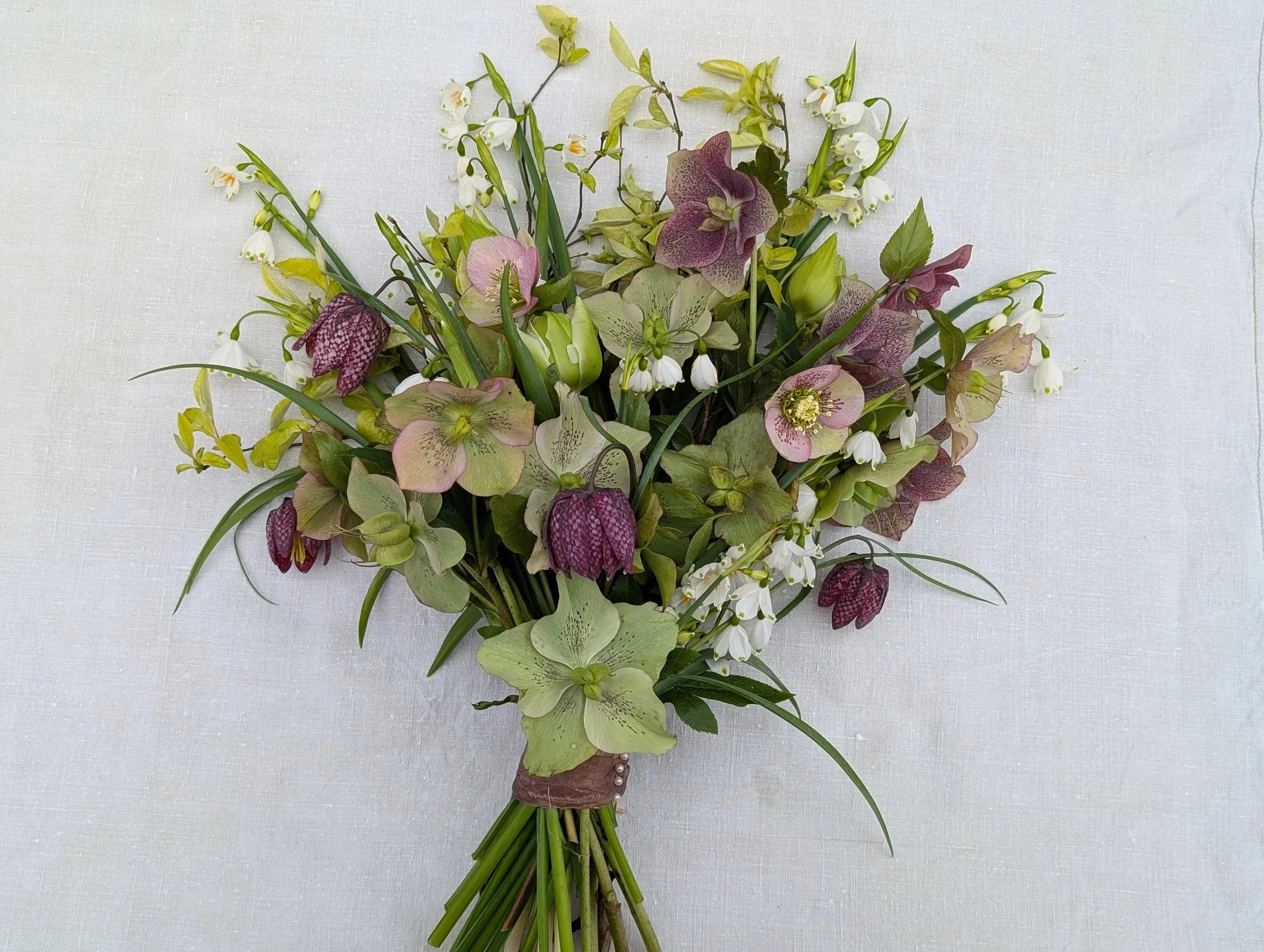 Spring bridal bouquet of hellebores and snakehead fritillaries with silk ribbon