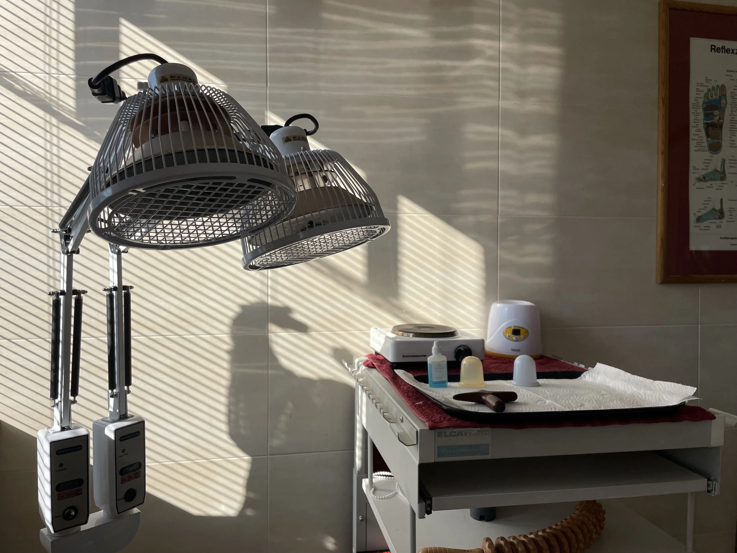 Behandlungsraum mit Lampe, medizinischem Zubehör und Trockentuch