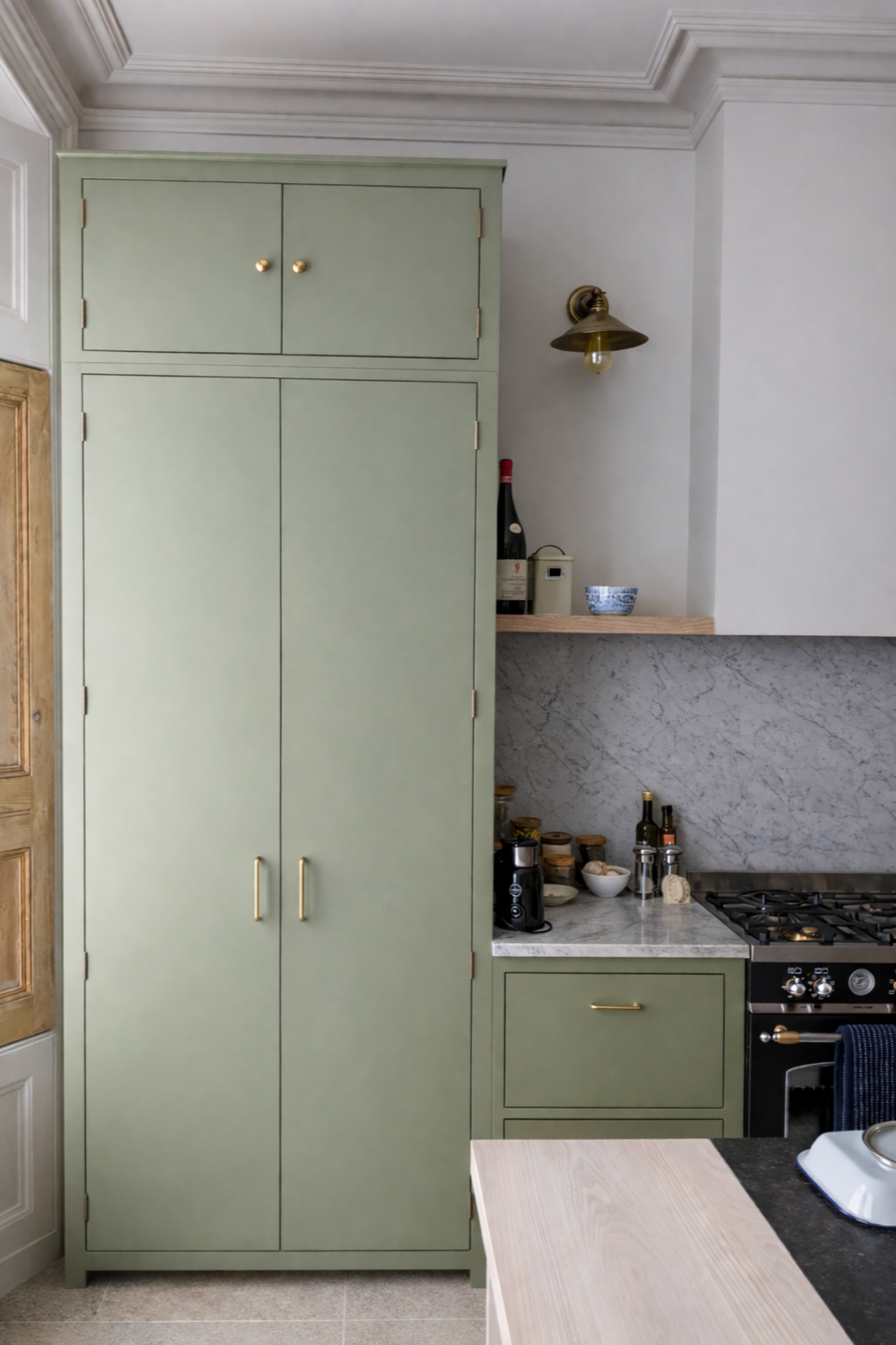 Tall kitchen pantry cabinetry with marble worktop and splashback