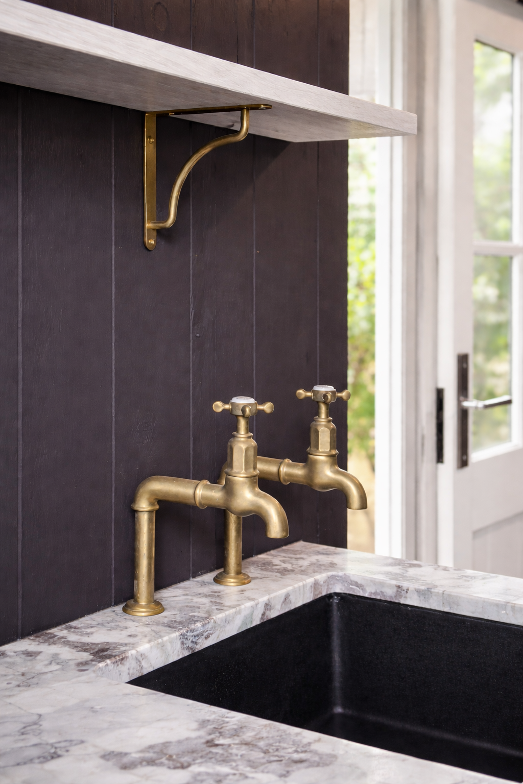 Brass taps above marble sink in garden shepherd hut