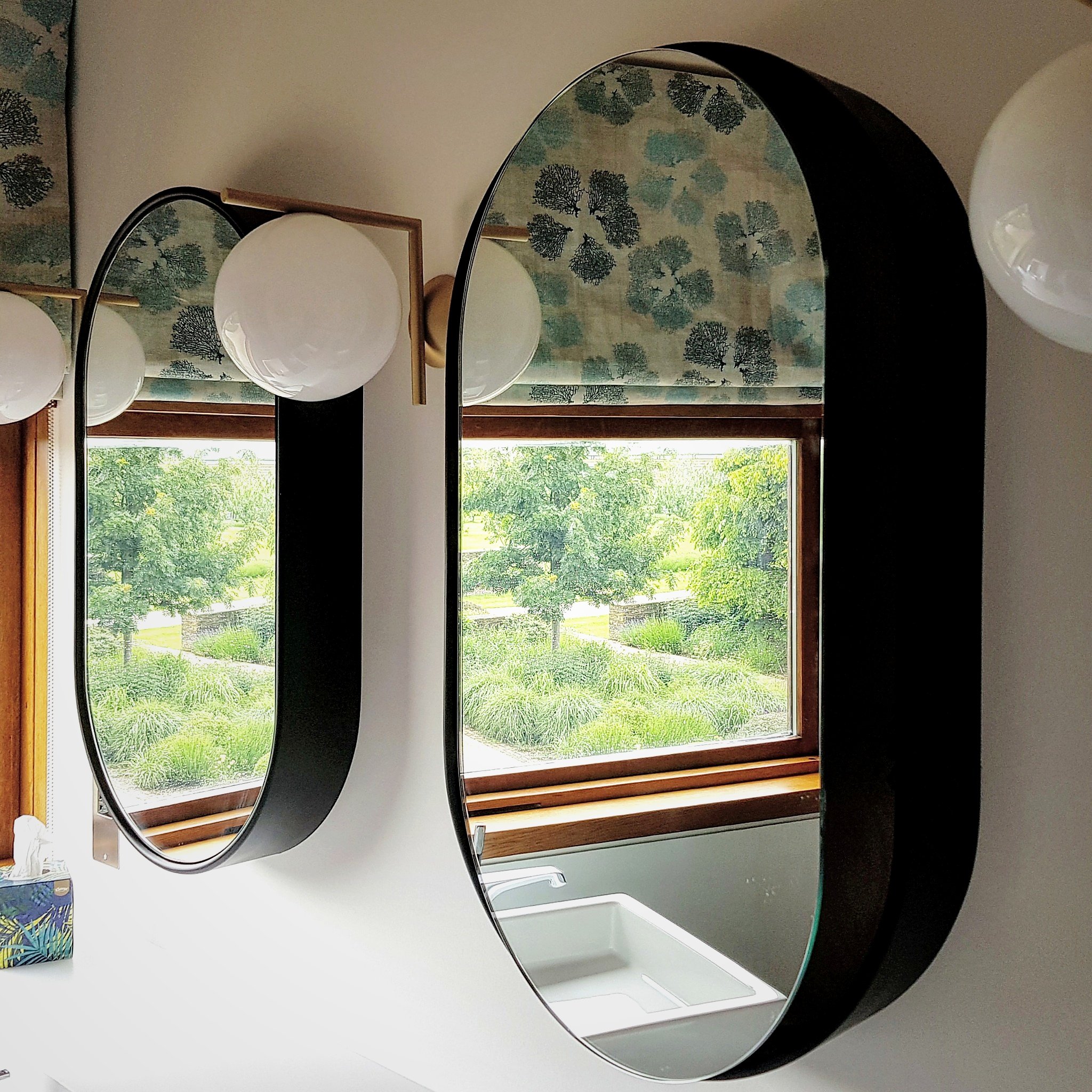 Bathroom mirror cabinet beside window