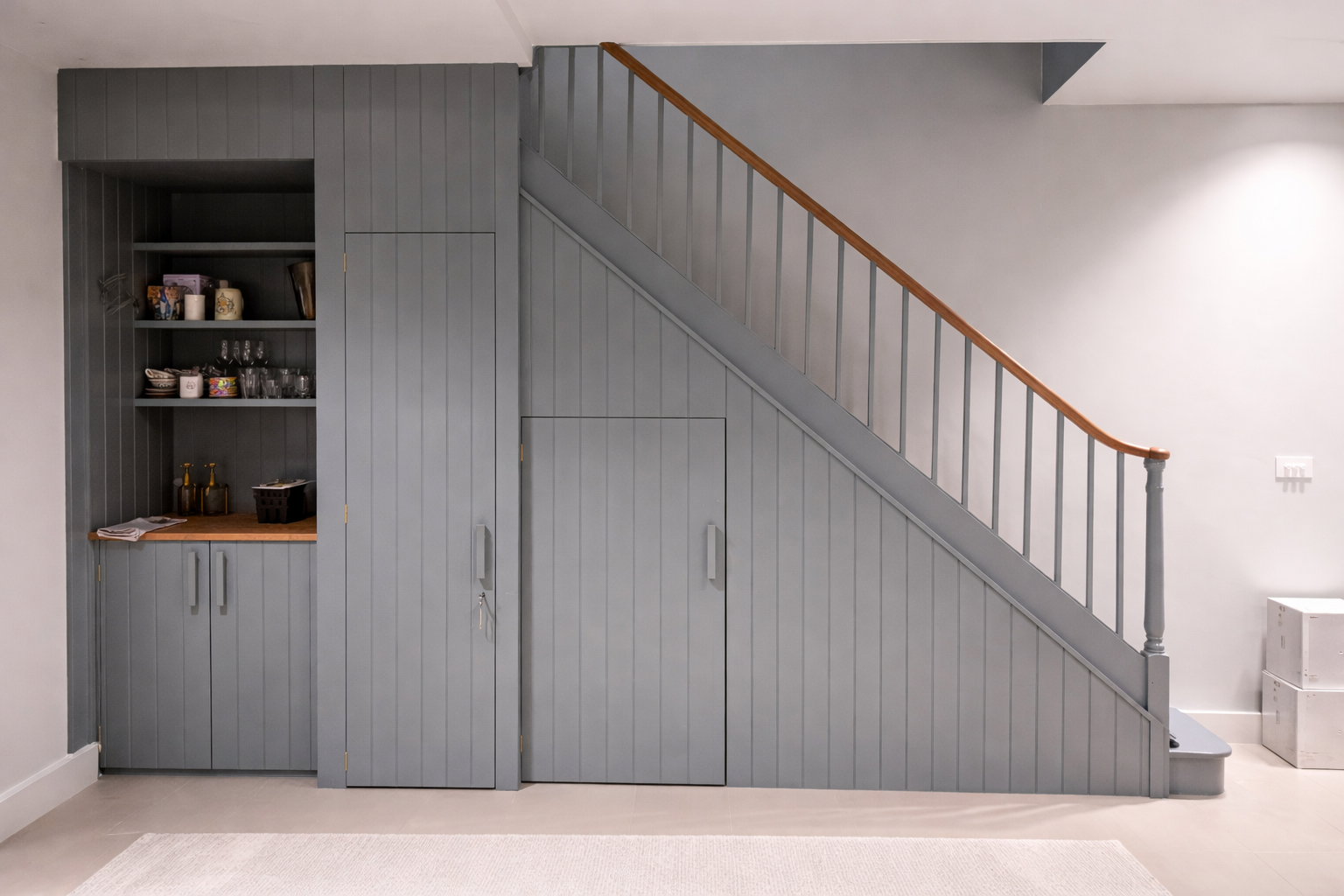 Under-stair joinery with sink, cupboard and open shelving