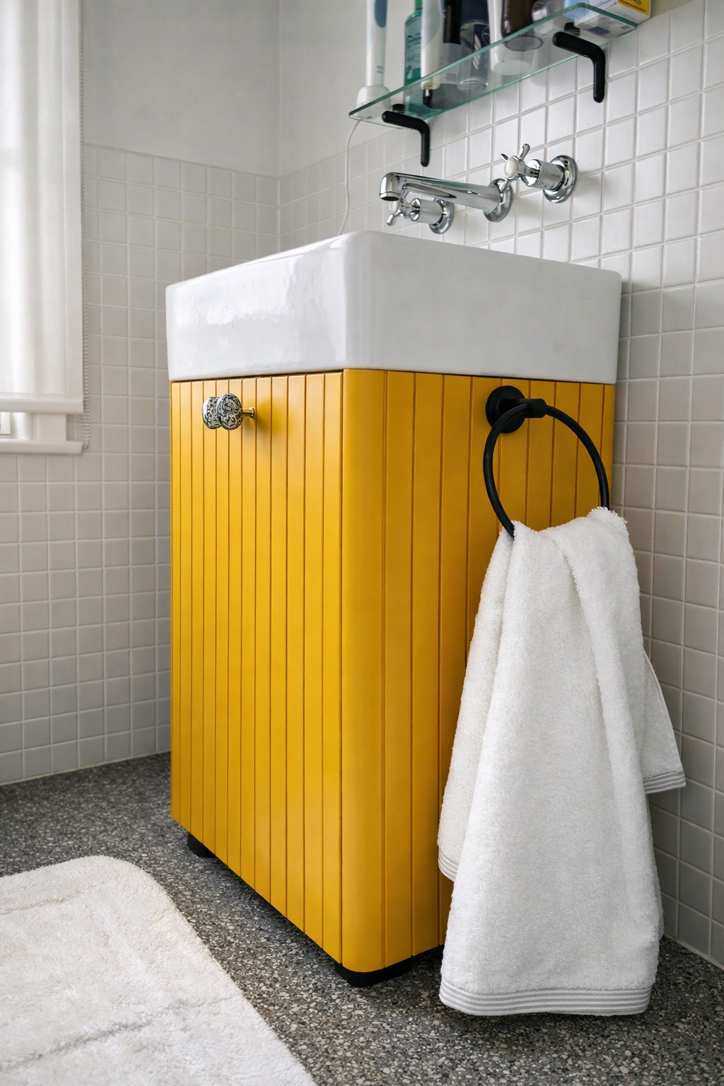 Yellow vanity unit with ceramic sink and wall-mounted taps