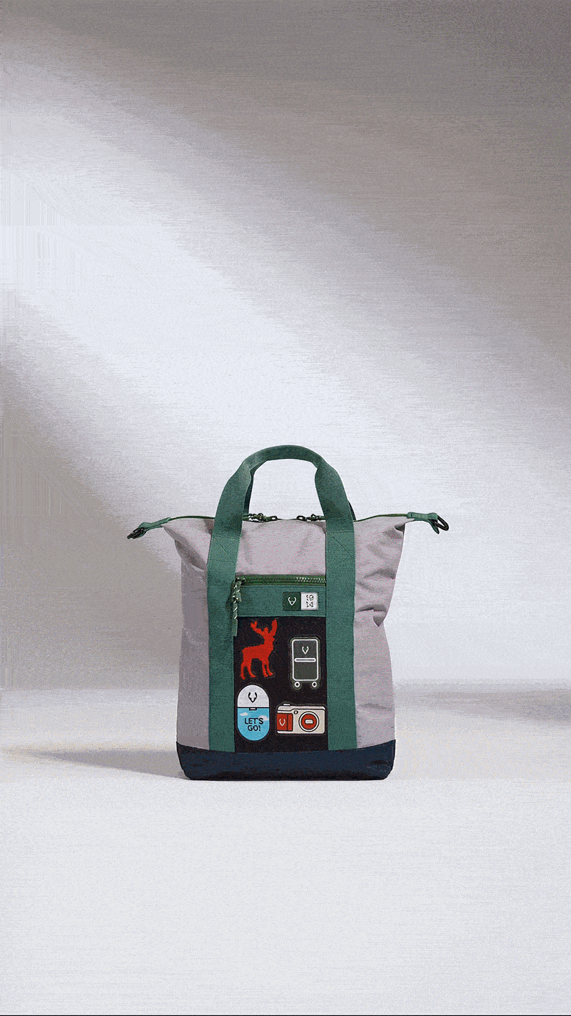 Pink and green convertible backpack with decorative patches, photographed against a neutral background