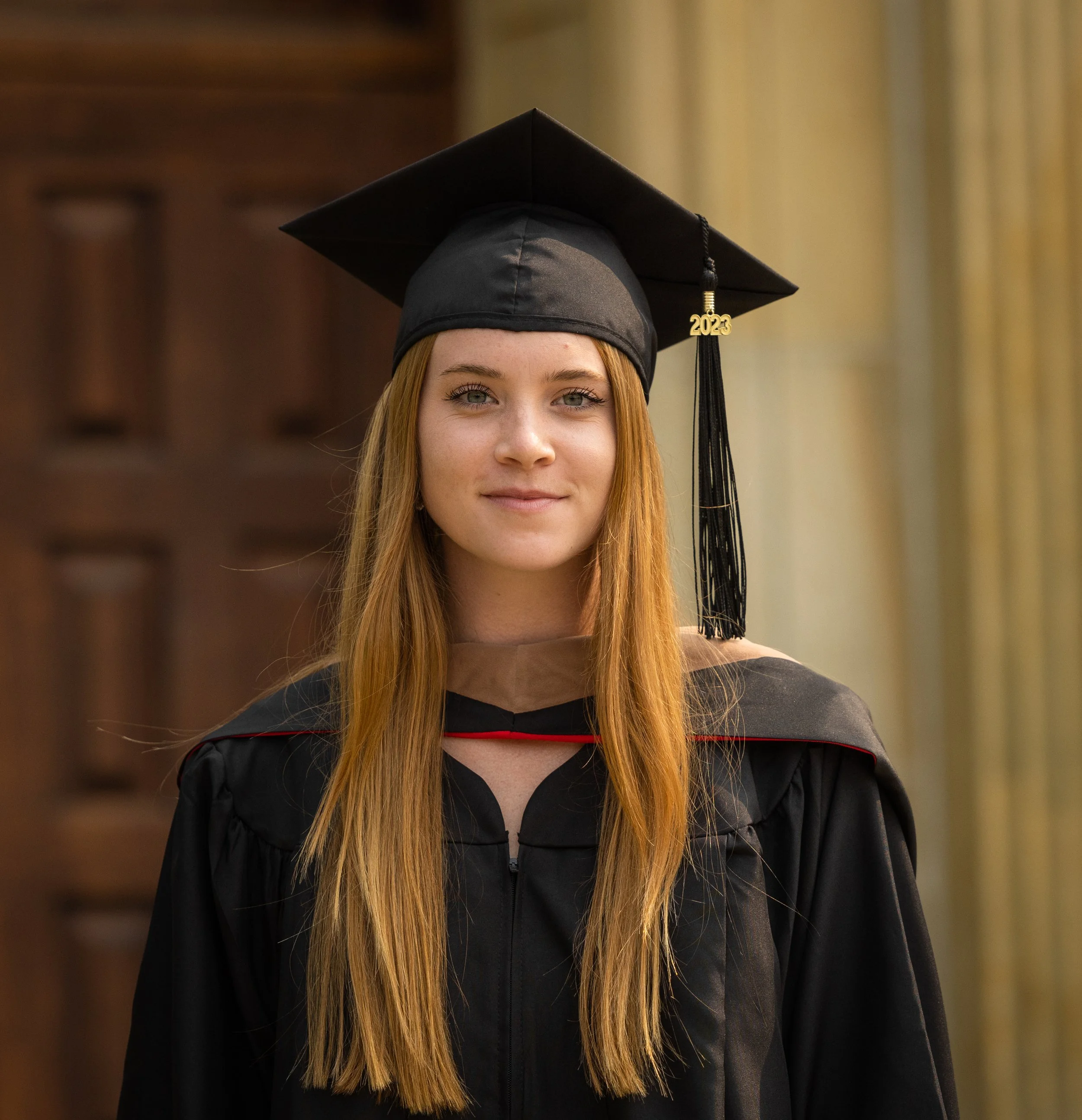 a front shot of a graduate with their cap and gown on