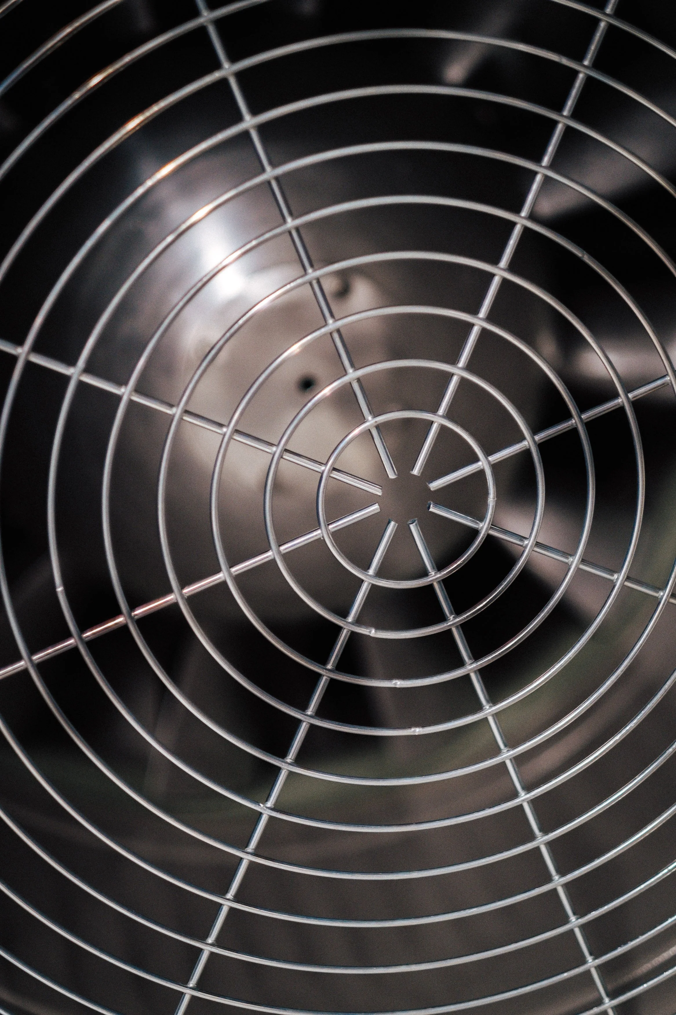 Nahaufnahme eines Metallventilators mit Gitterabdeckung.