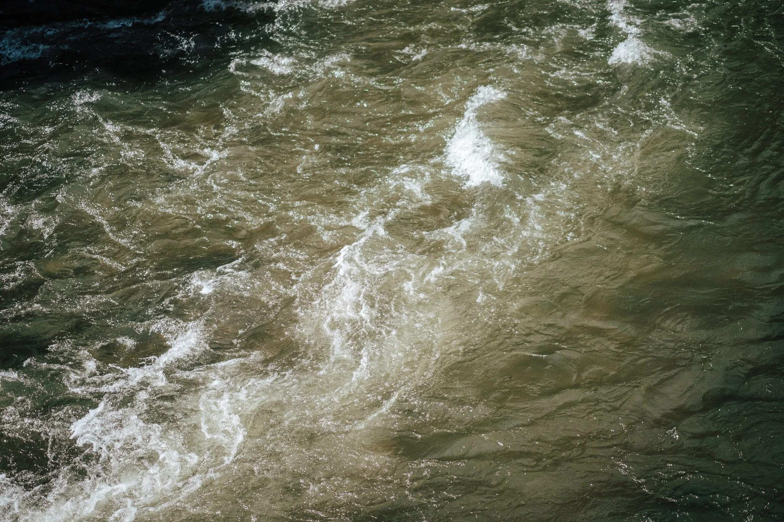 Wasser mit kleinen Wellen und Schaum.