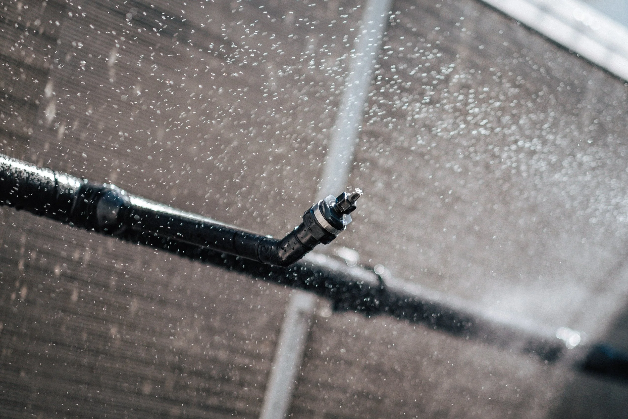 Eine Wasserpistole sprüht Wasser, es entstehen Wassertröpfchen und ein feiner Wasserstrahl.