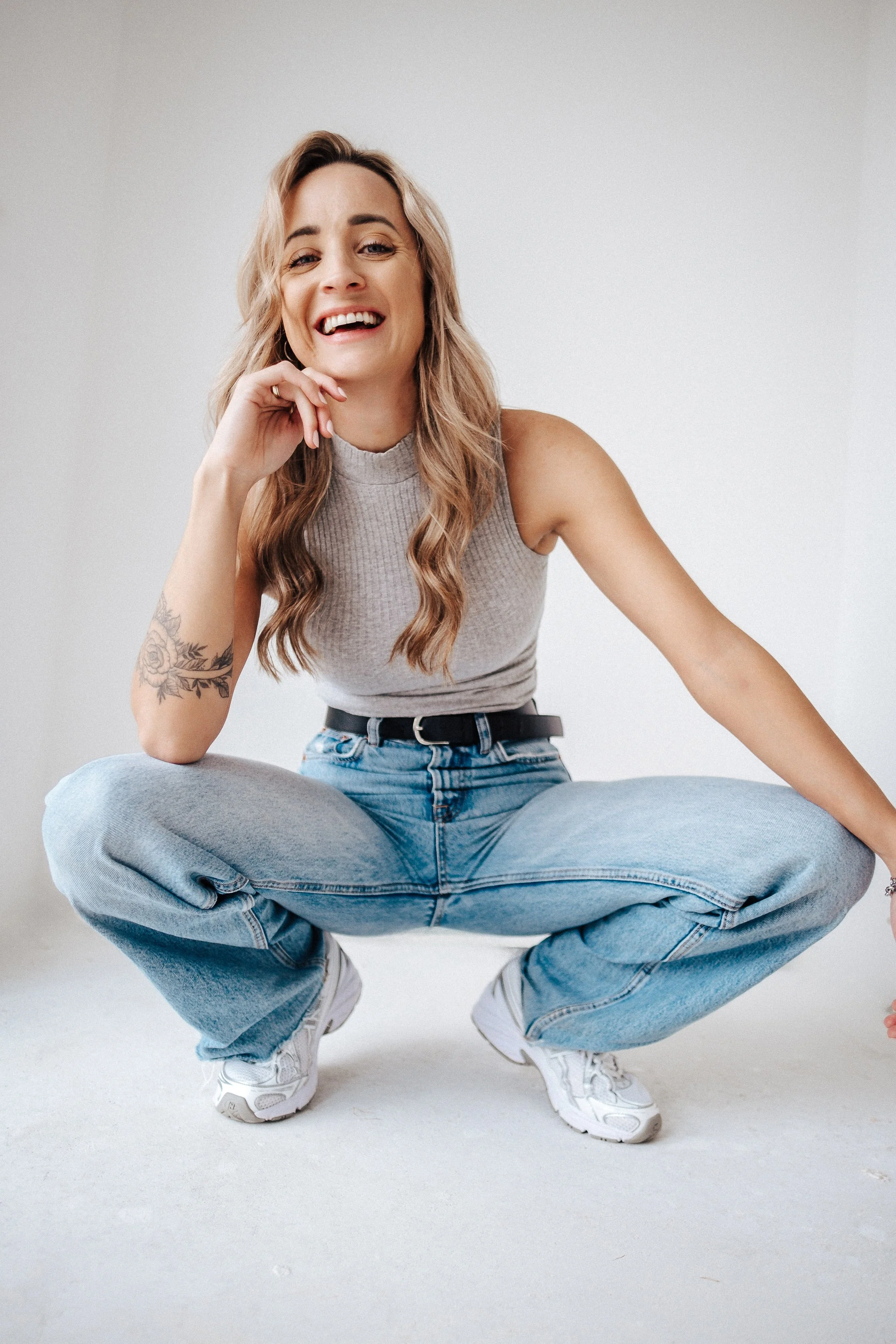 Lächelnde junge Frau im angesagten Freizeitlook, die in die Kamera schaut.