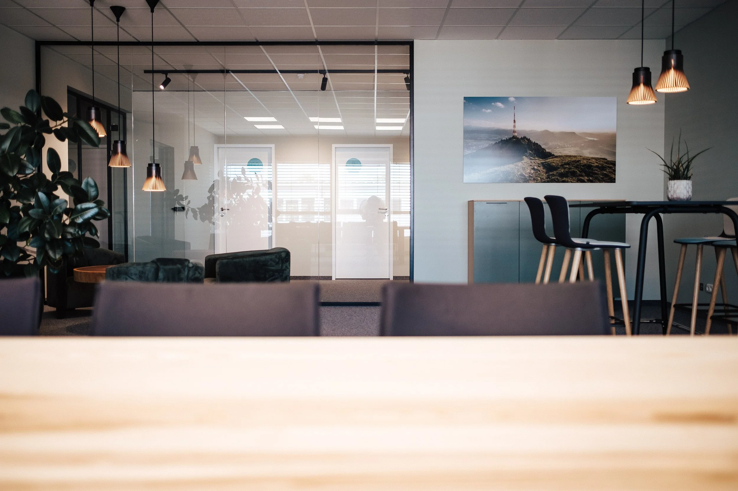 Modernes Büro mit Sitzbereich, einen großen Wandbild und Barhockern.