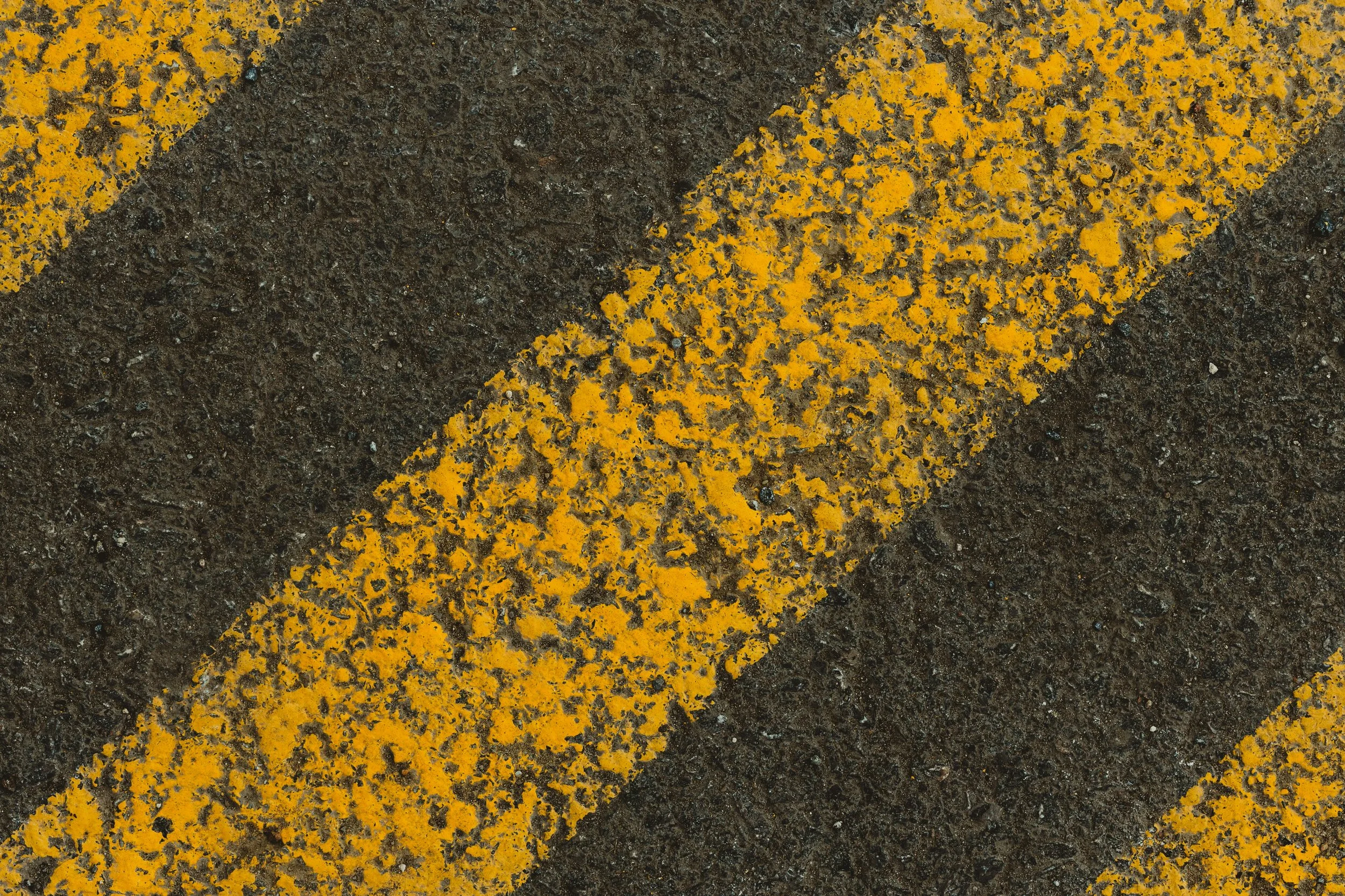 Voie jaune peinte sur une surface de route en pierre.