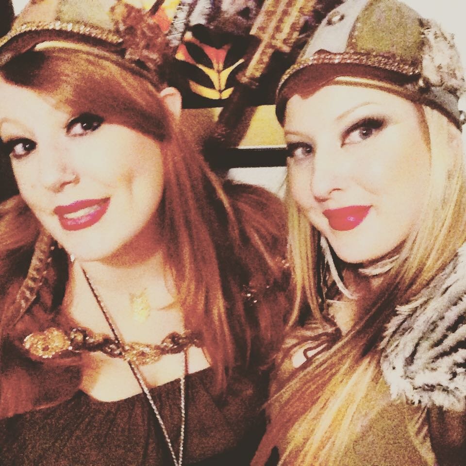Two women dressed in pirate costumes, wearing pirate hats and accessories, smiling for the camera.