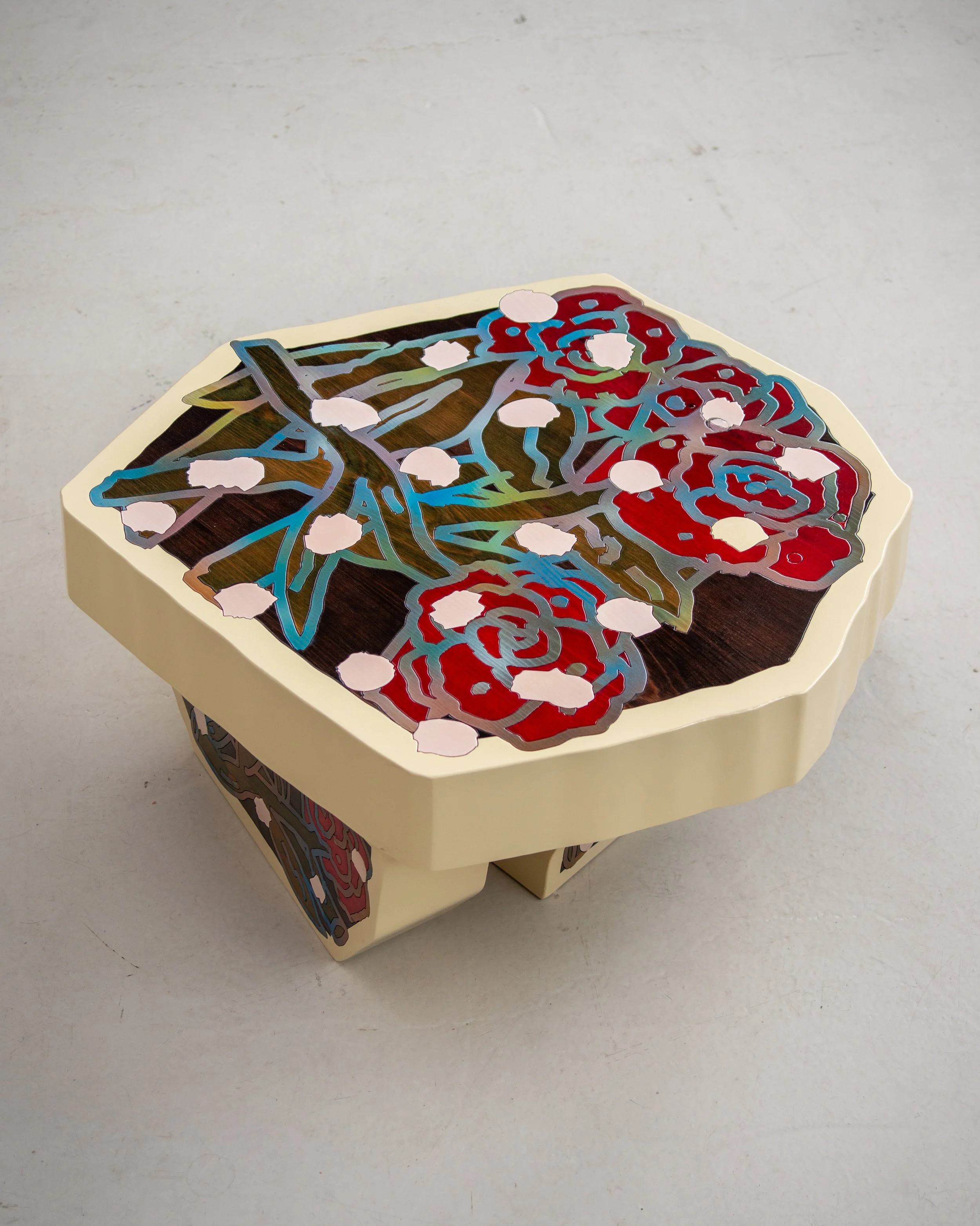 Decorative polygonal table with colorful floral design on the surface and sides.