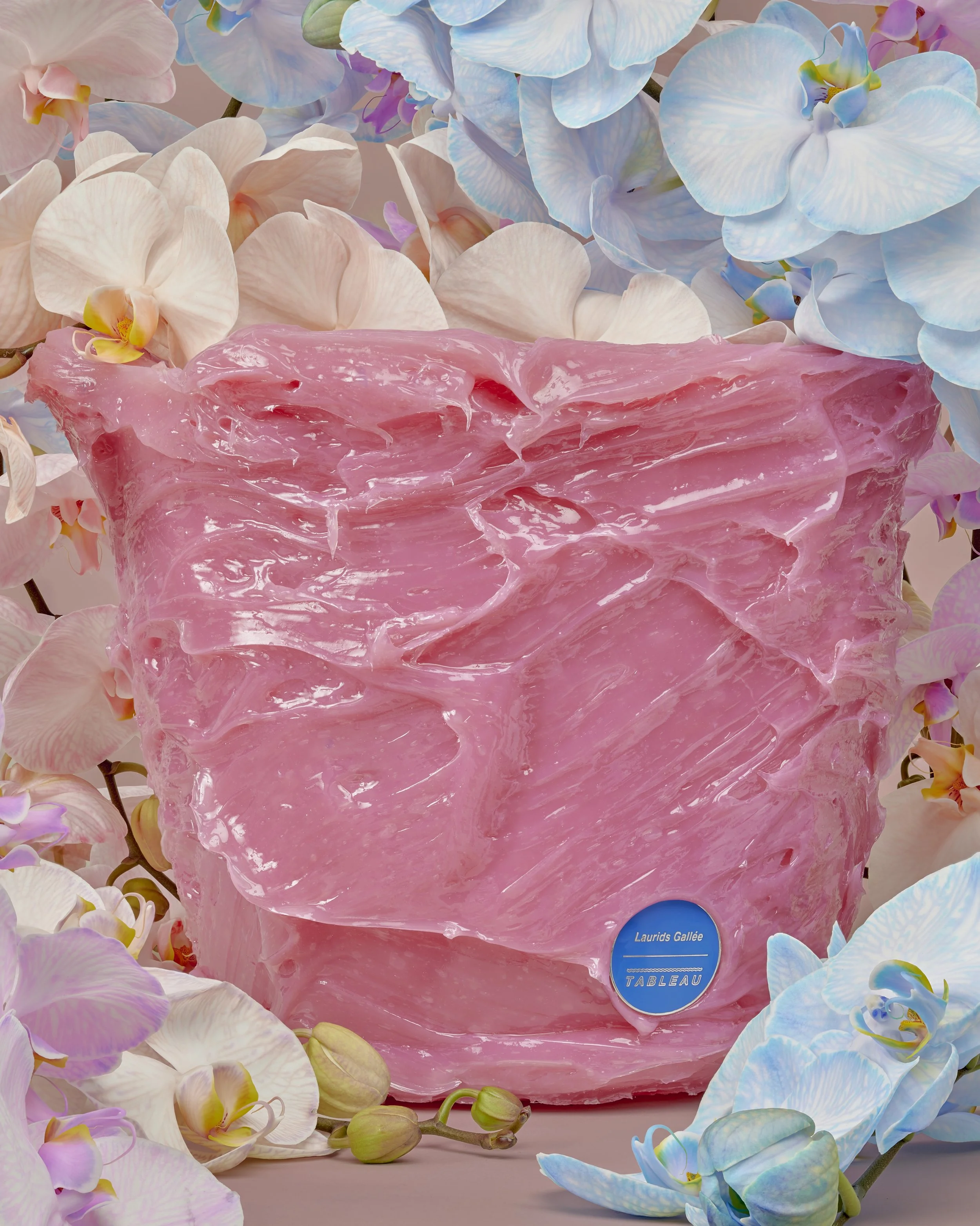 Pink textured vase surrounded by white and blue orchids.