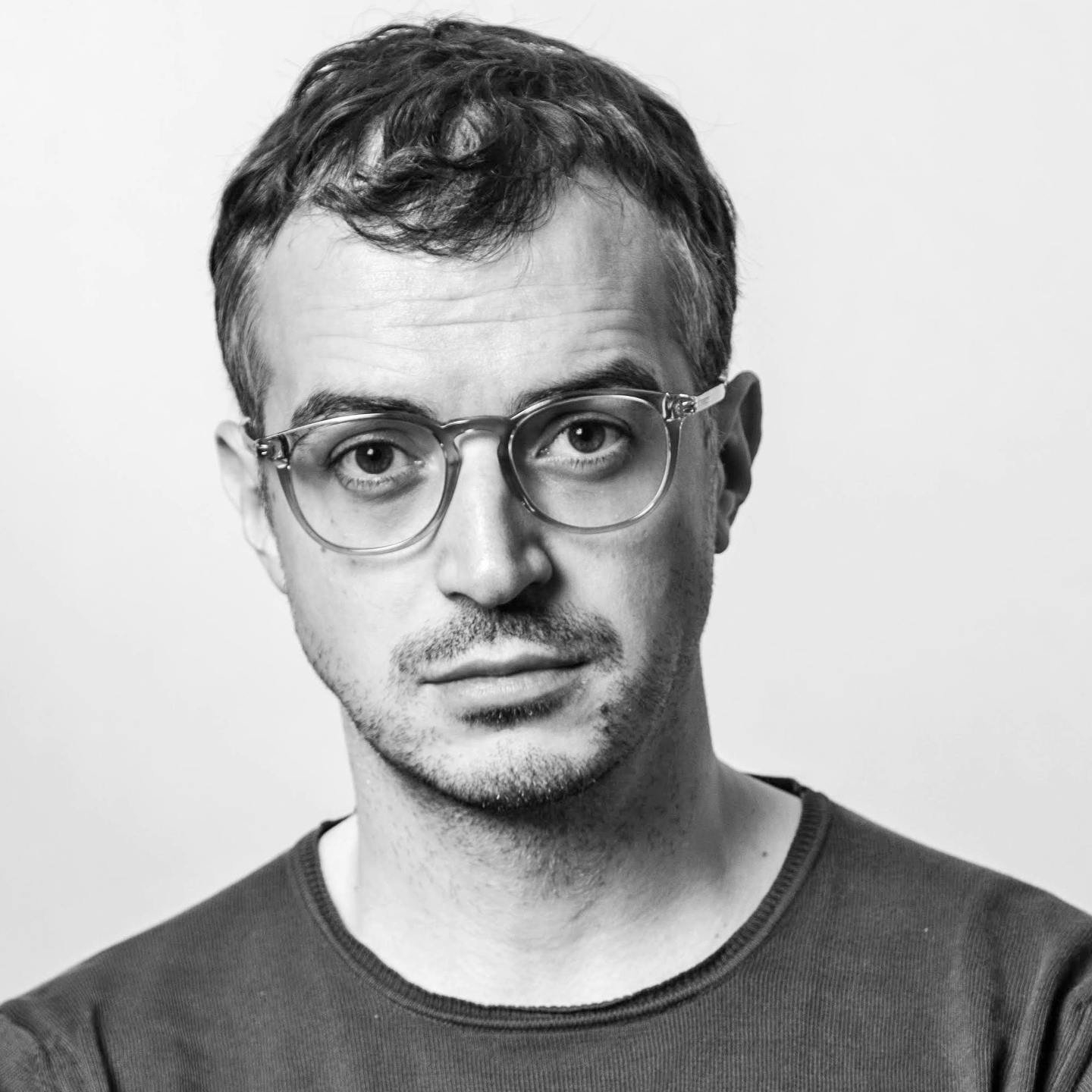 Portrait of a person wearing glasses and a sweater.