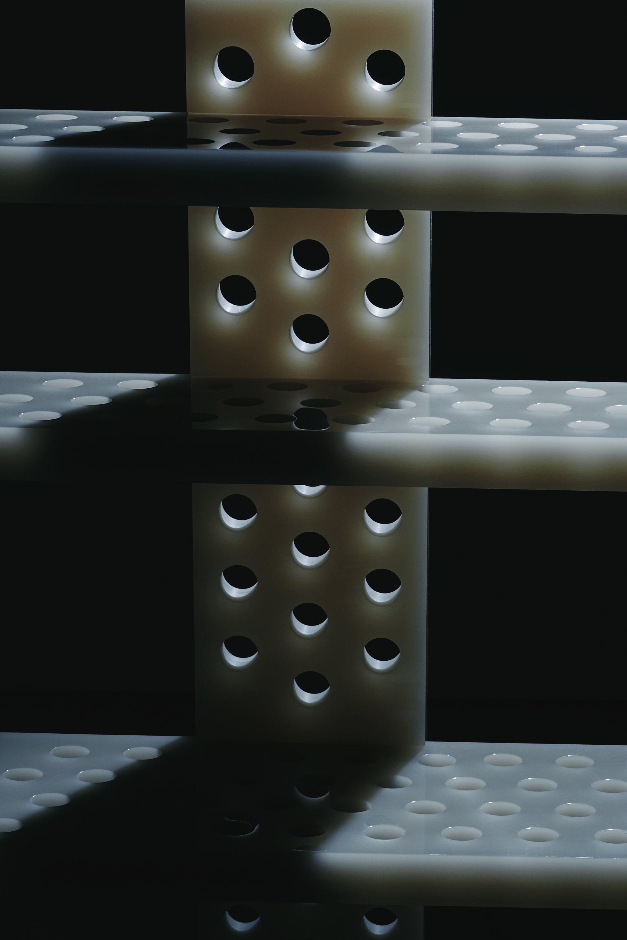 Abstract stacked blocks with circular holes against a dark background