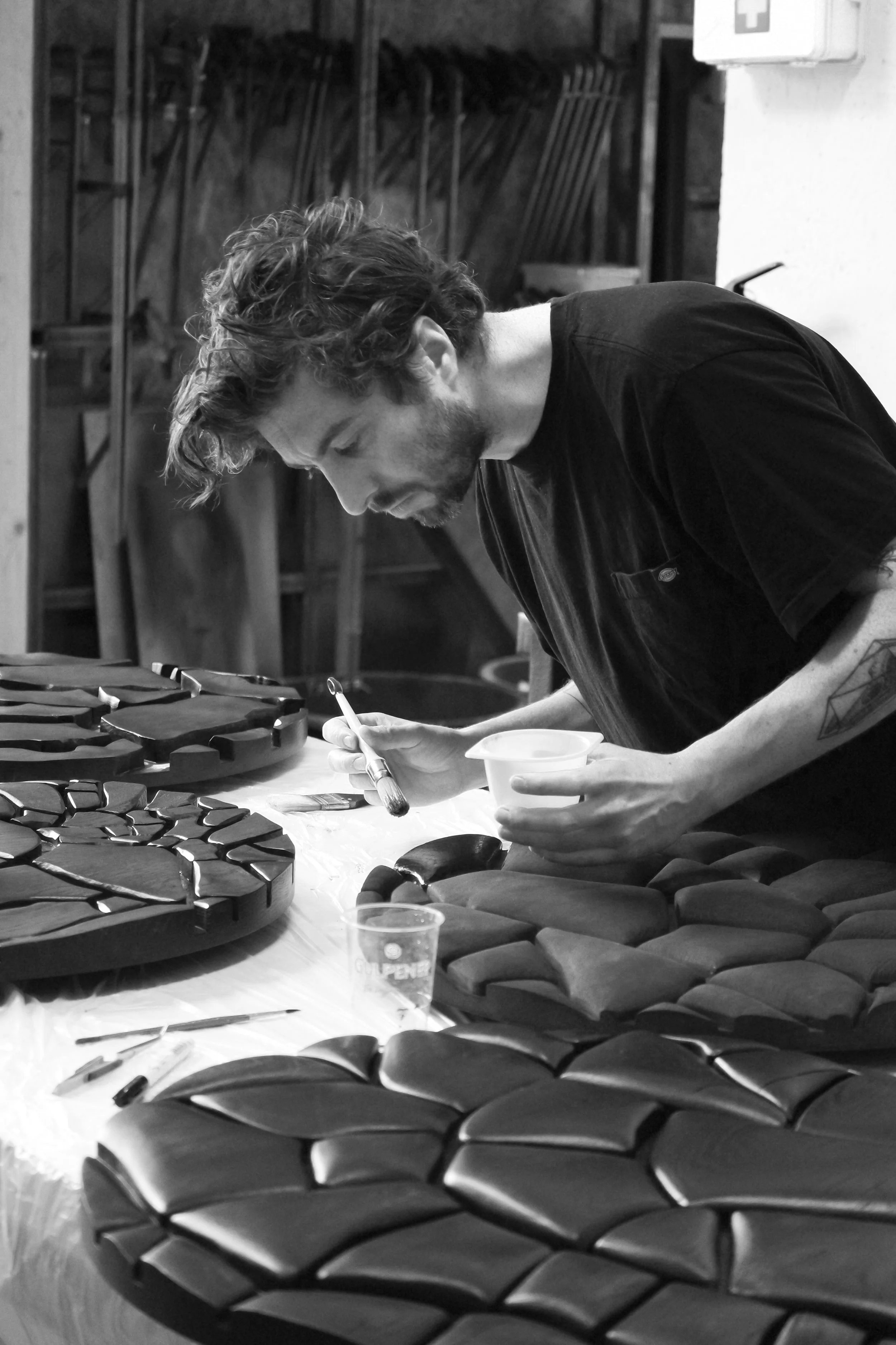 Person painting geometric sculptures in a workshop