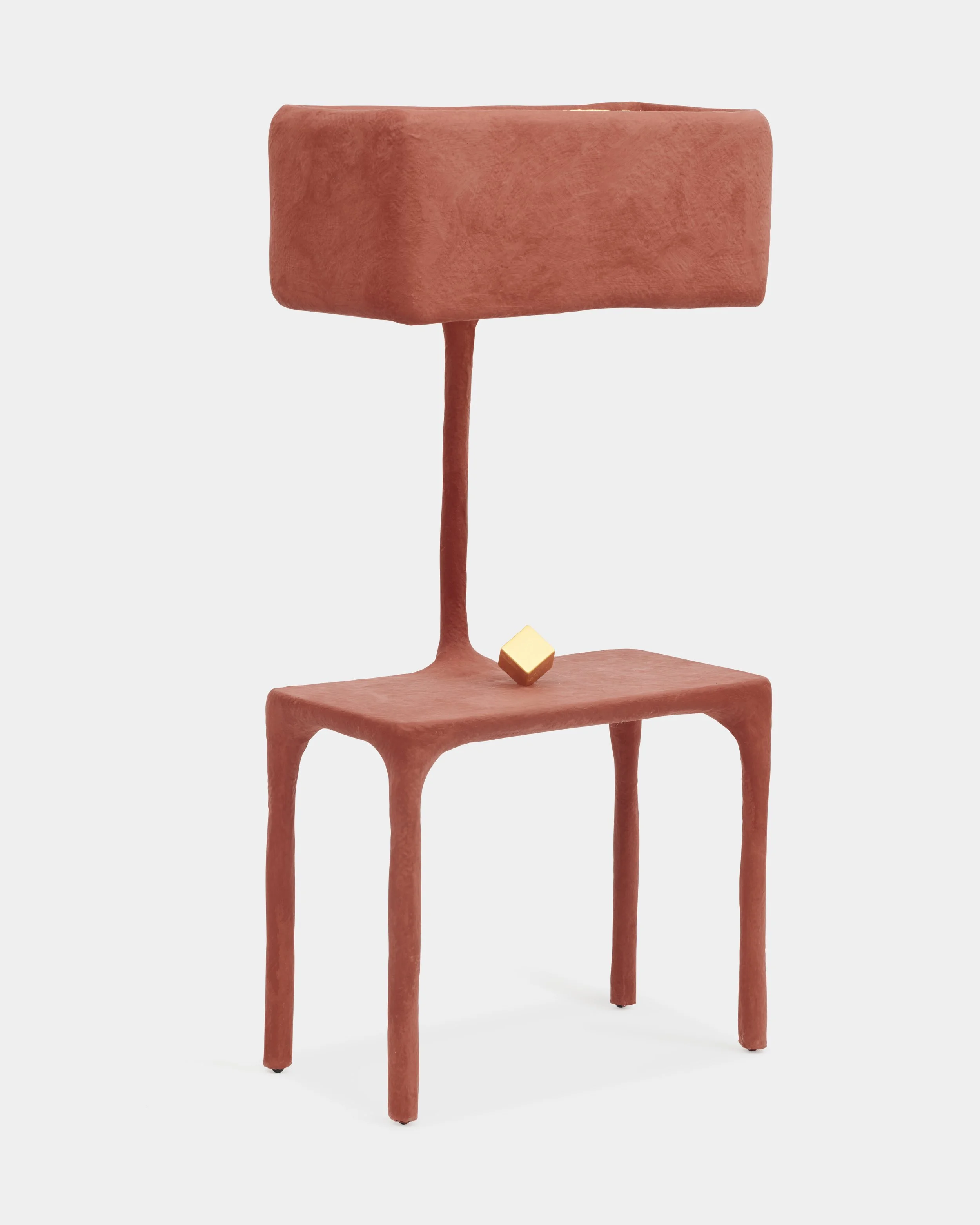 Sculptural chair with rectangular backrest in reddish-brown color, yellow cube on seat