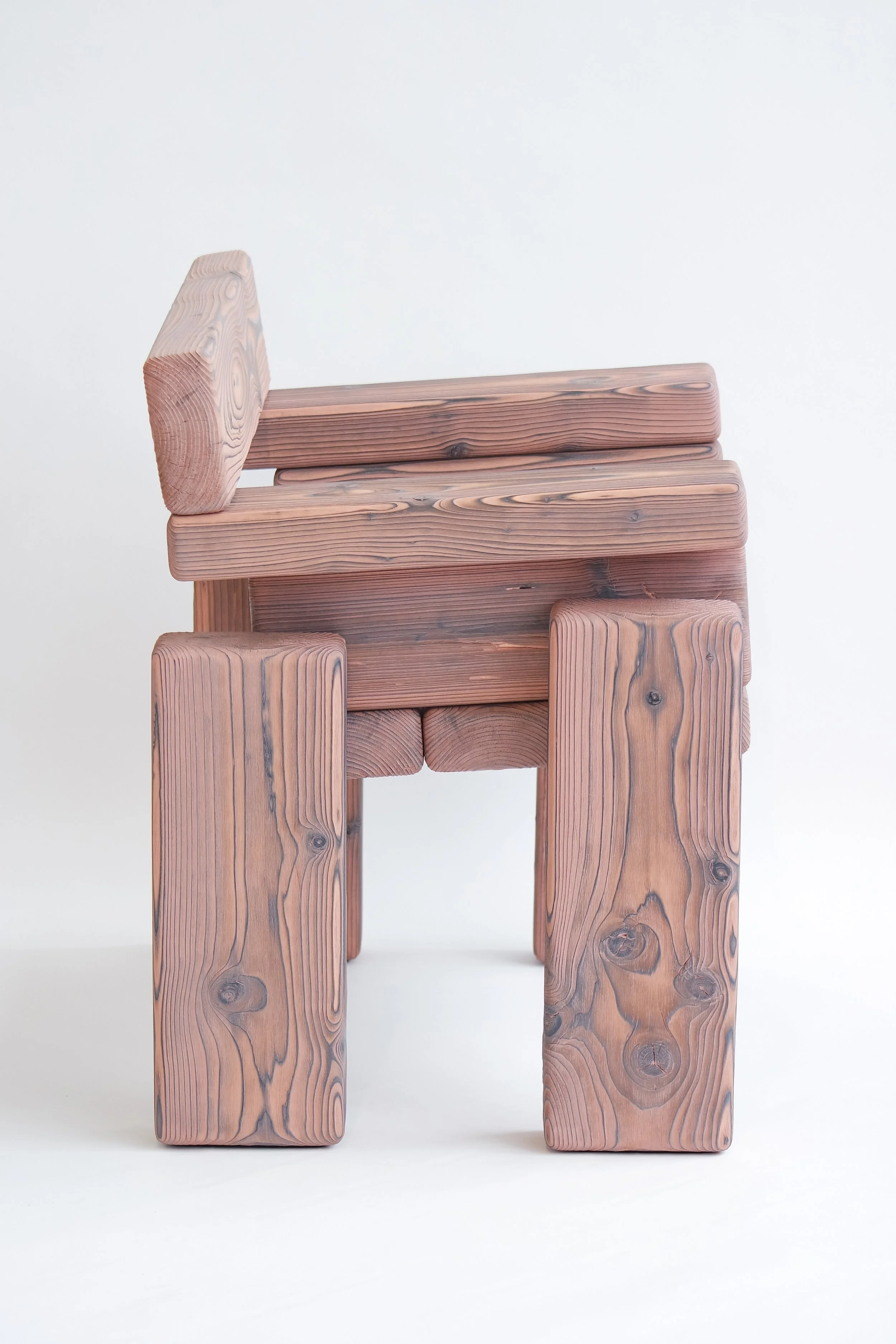 Wooden chair with a blocky, rustic design against a plain background.