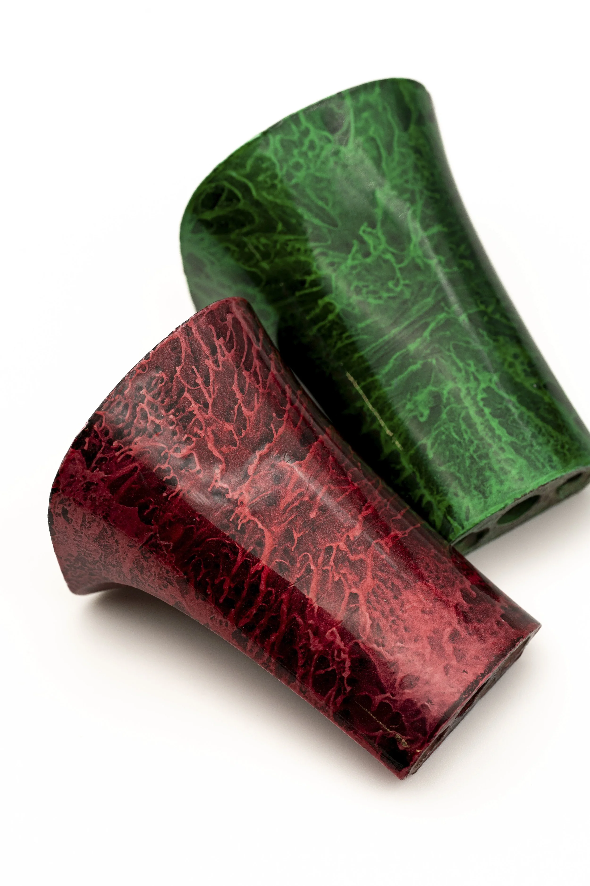 Dos objetos con forma de mago, uno rojo y uno verde, con textura de vetas y patrones marmoleados.