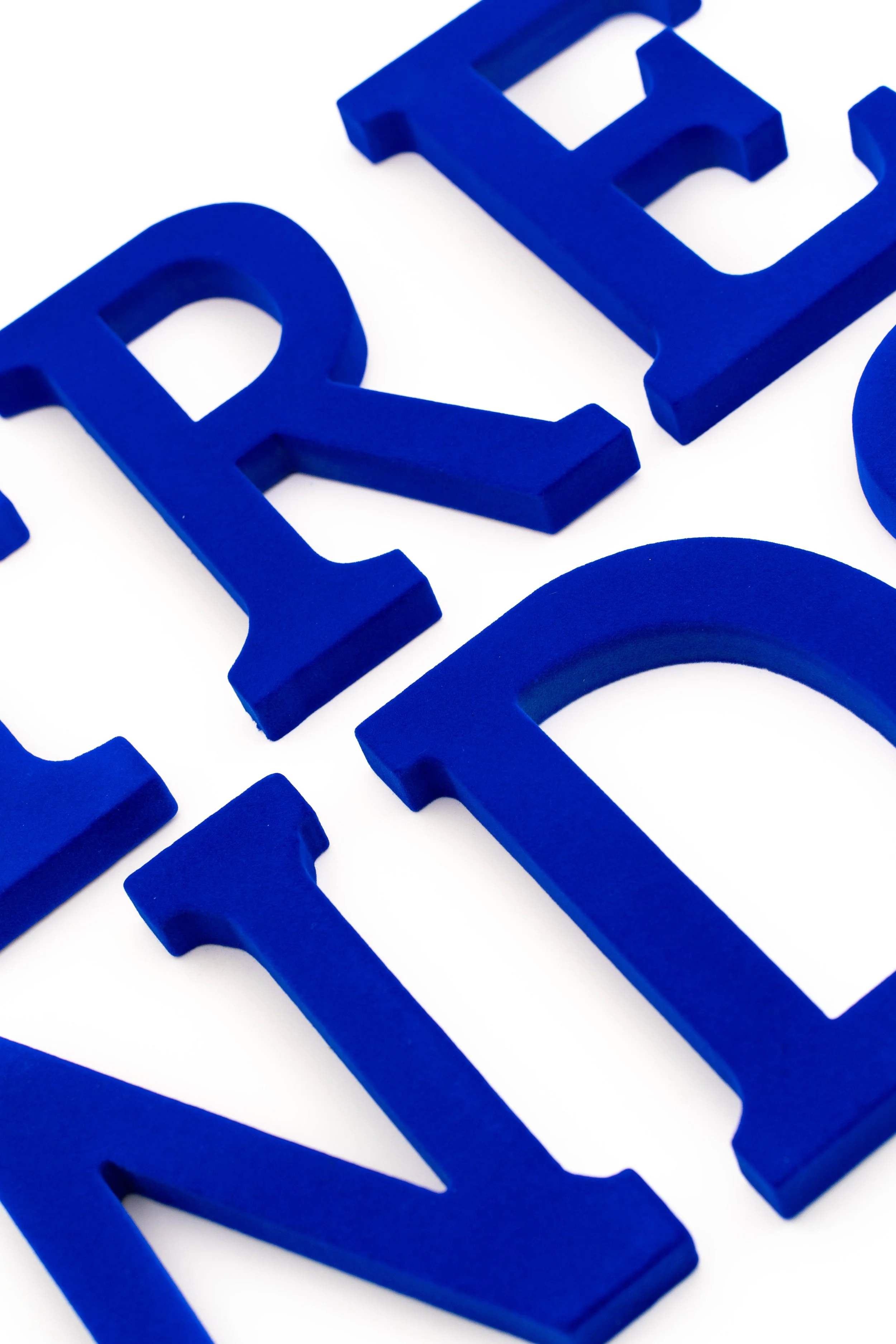 Letras azules en relieve sobre fondo blanco.