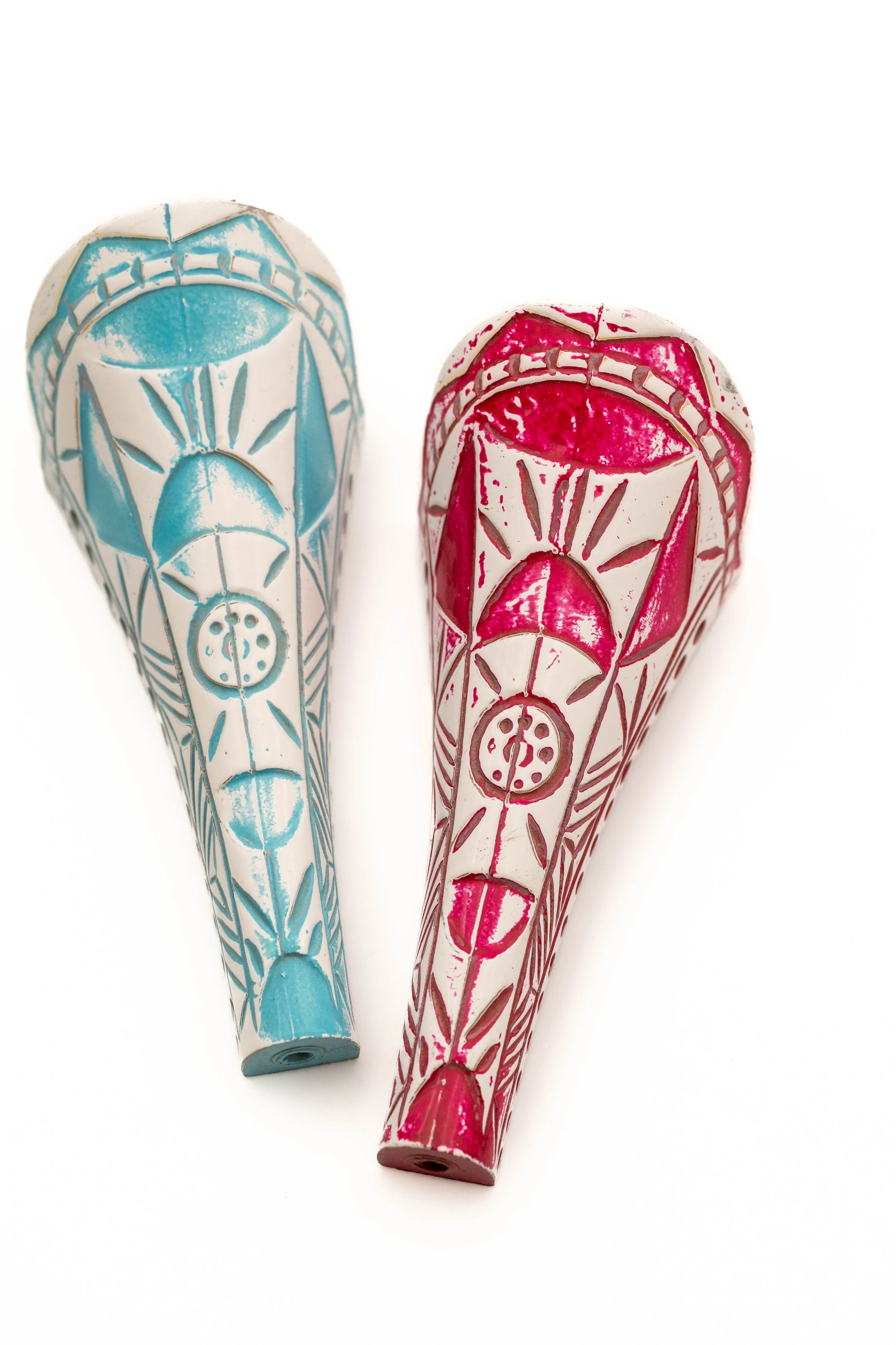 Lápices decorados con diseños coloridos en azul y rosa, con patrones de líneas y formas geométricas, colocados sobre un fondo blanco.