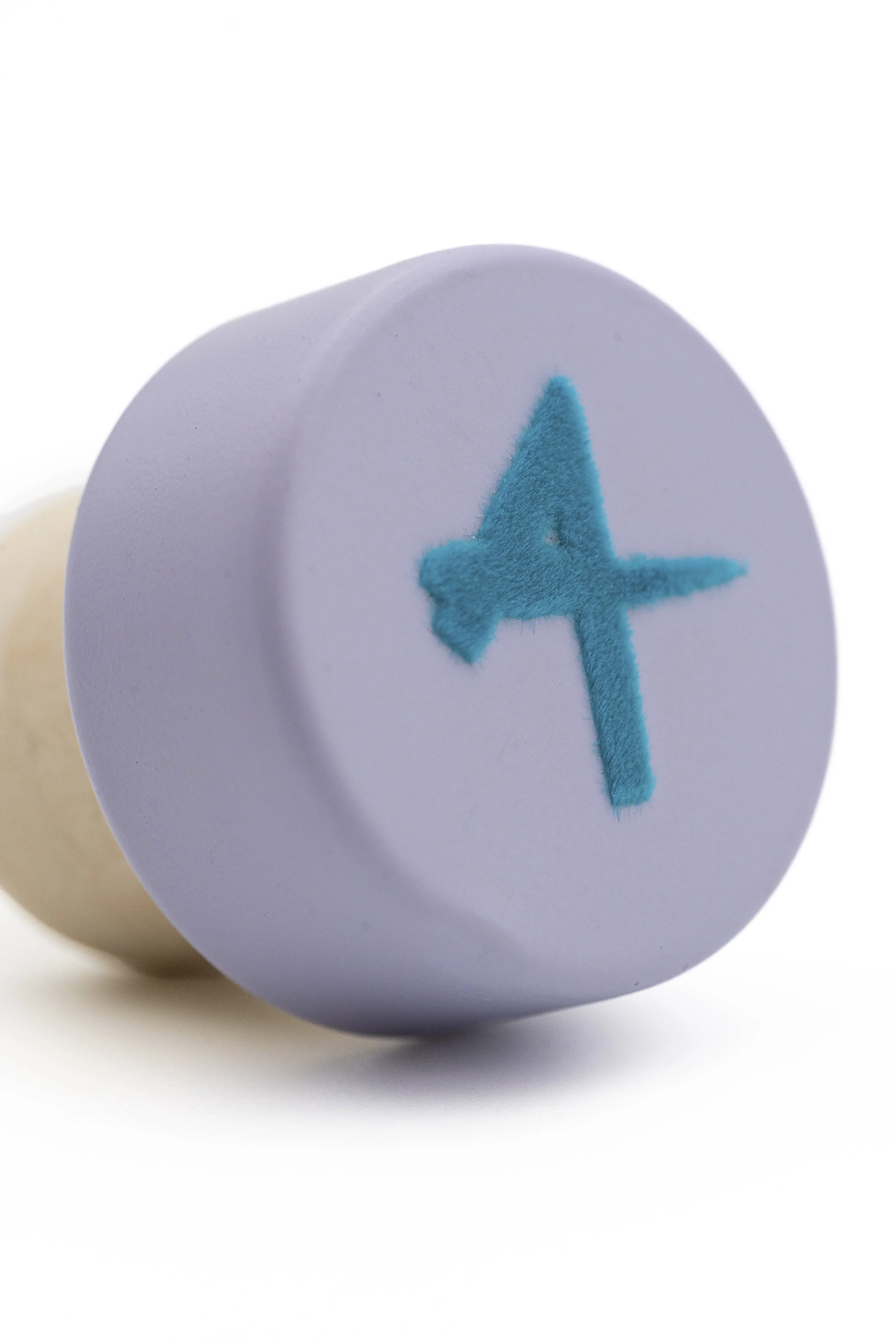 Círculo de papel con un bordado en forma de estrella de color azul, en un fondo blanco.