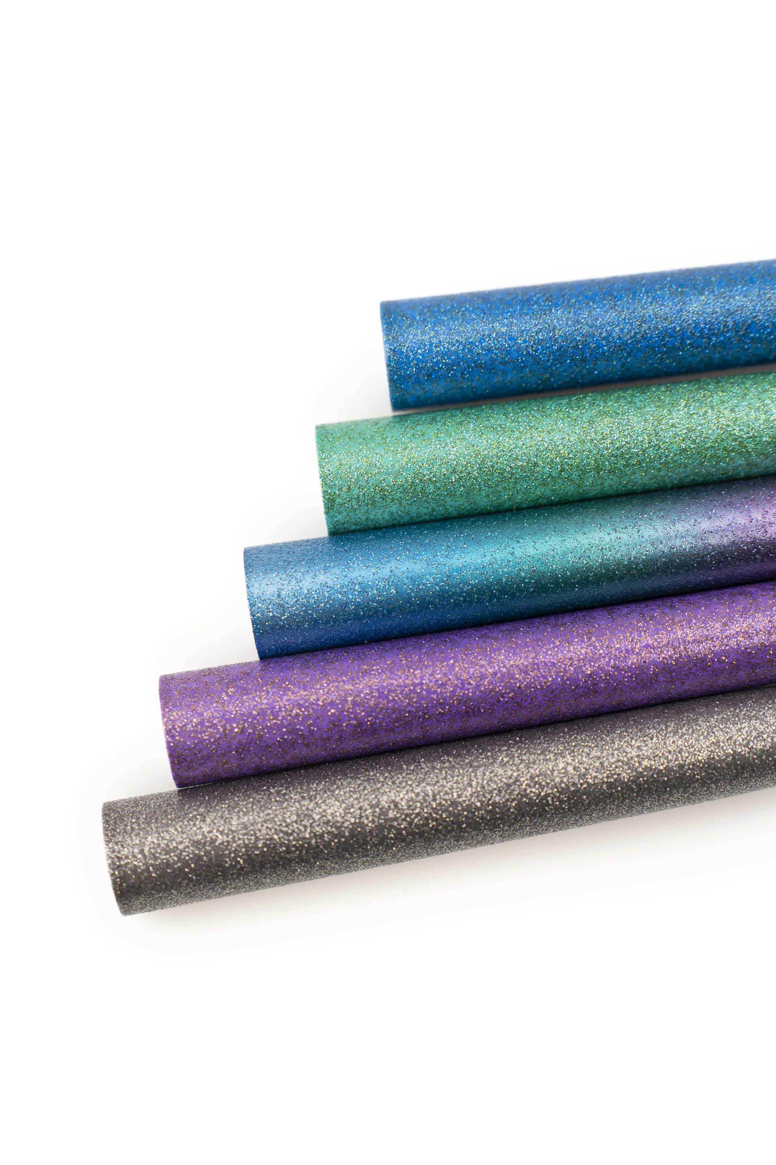 Lápices decorados con diseños coloridos en azul y rosa, con patrones de líneas y formas geométricas, colocados sobre un fondo blanco.