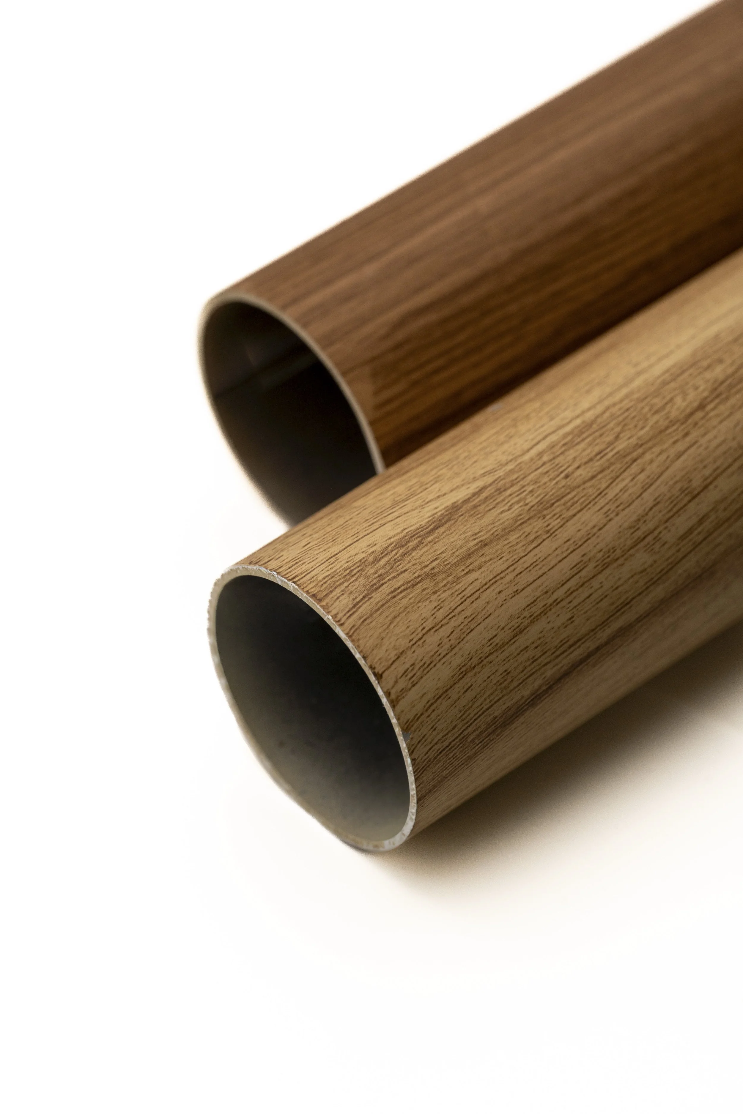 Dos tubos de madera con interior negro, colocados en ángulo con fondo blanco.