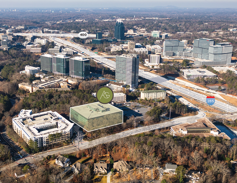 Aerial view of a cityscape with roads, buildings, and trees, including the label '400' on a highway and '285' on another highway, with a highlighted building and a green logo near Ashford Dunwoody Blvd.