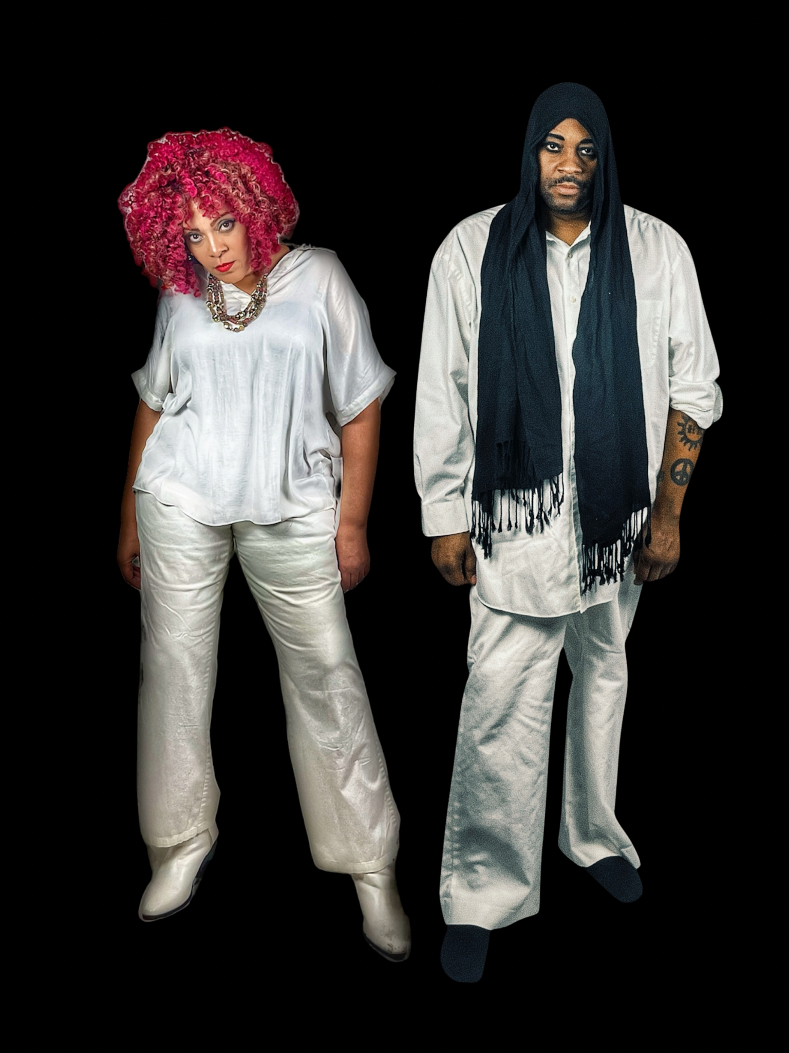 Two mannequins dressed in stylish clothing against a black background, one with bright pink curly hair and the other with long black hair and tattoos on the arm.