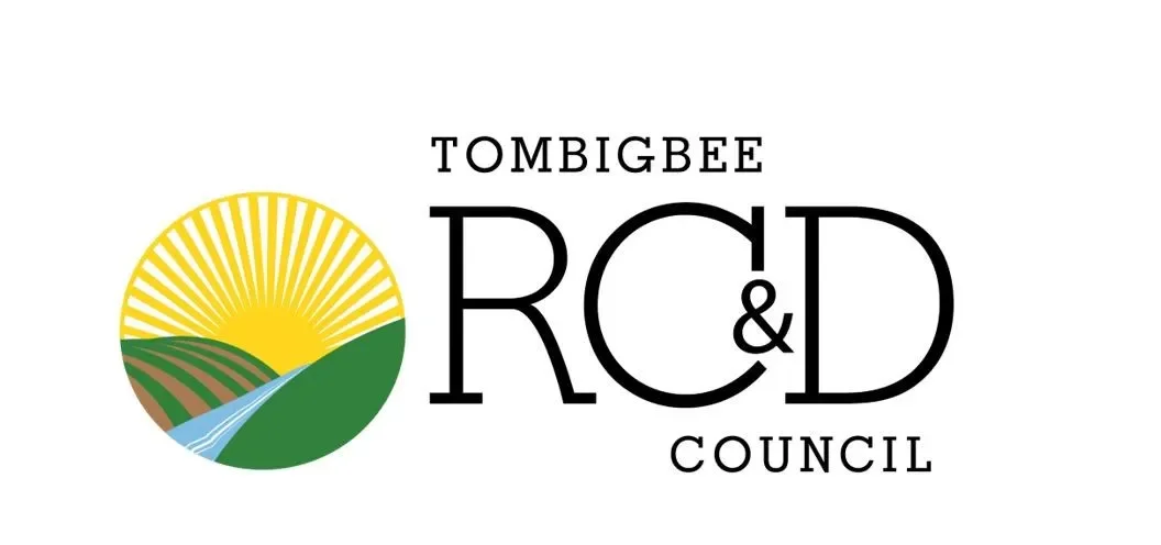 Logo with a landscape featuring a yellow sun, green hills, a blue stream, and brown soil, accompanied by the text "Tombigbee RCD Council".