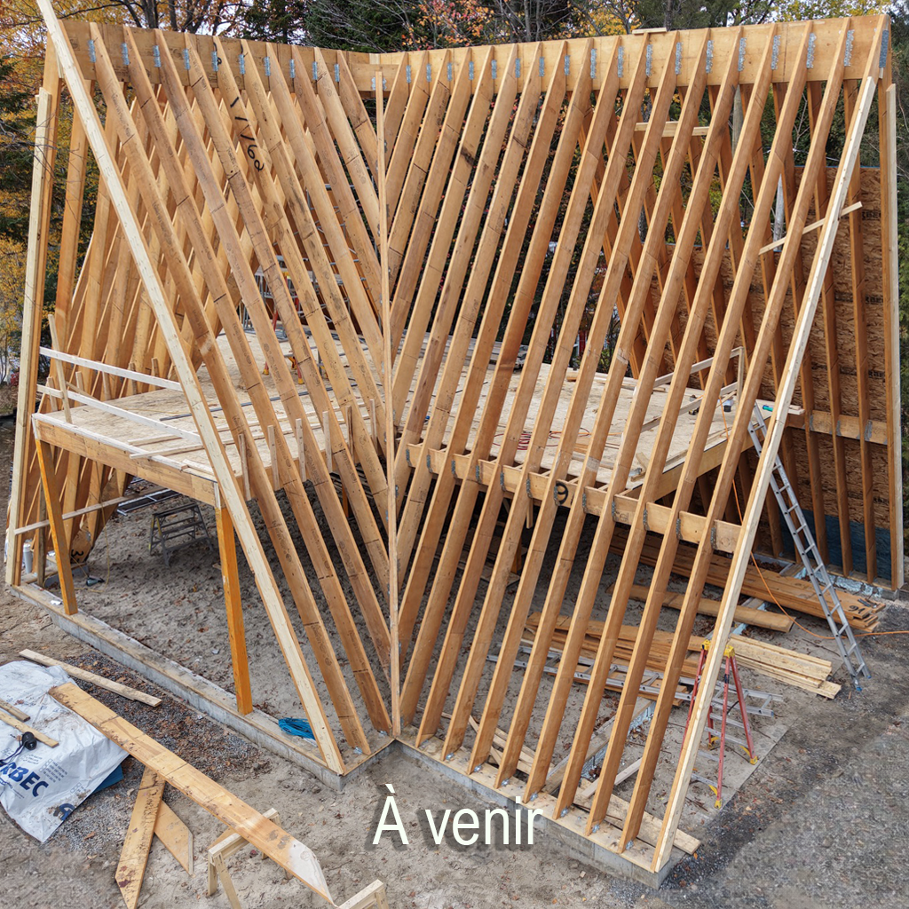 Under construction wooden framing for a building, with vertical and angular wooden beams.