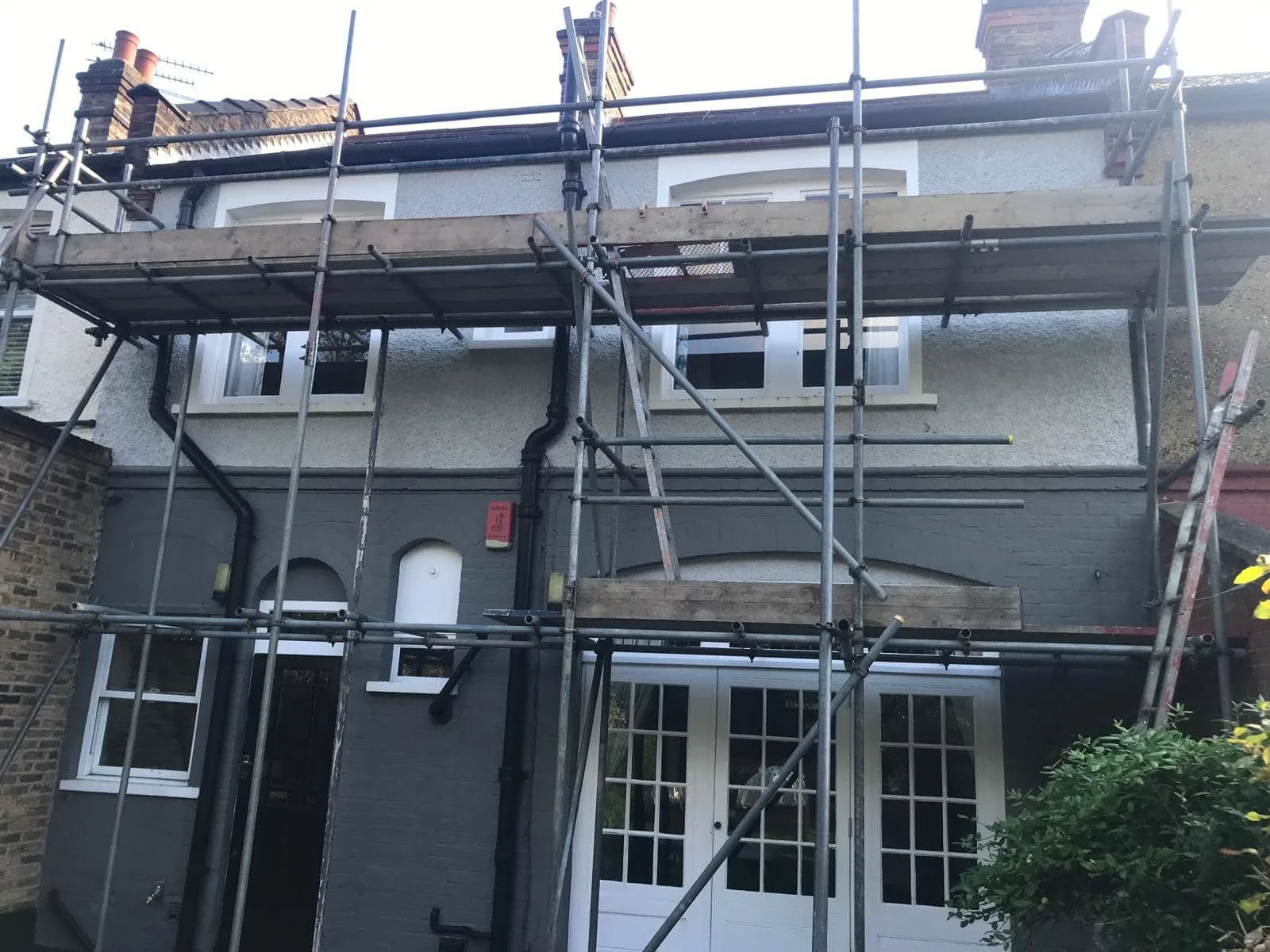 Exterior of a house with scaffolding around it, indicating construction or renovation work by K G Croft in North London.